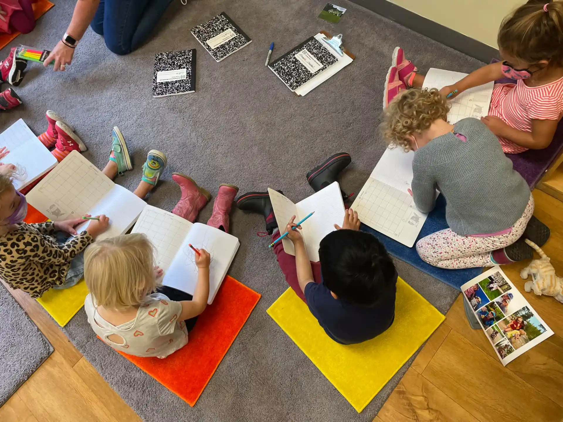 a group of children sitting on the floor reading books