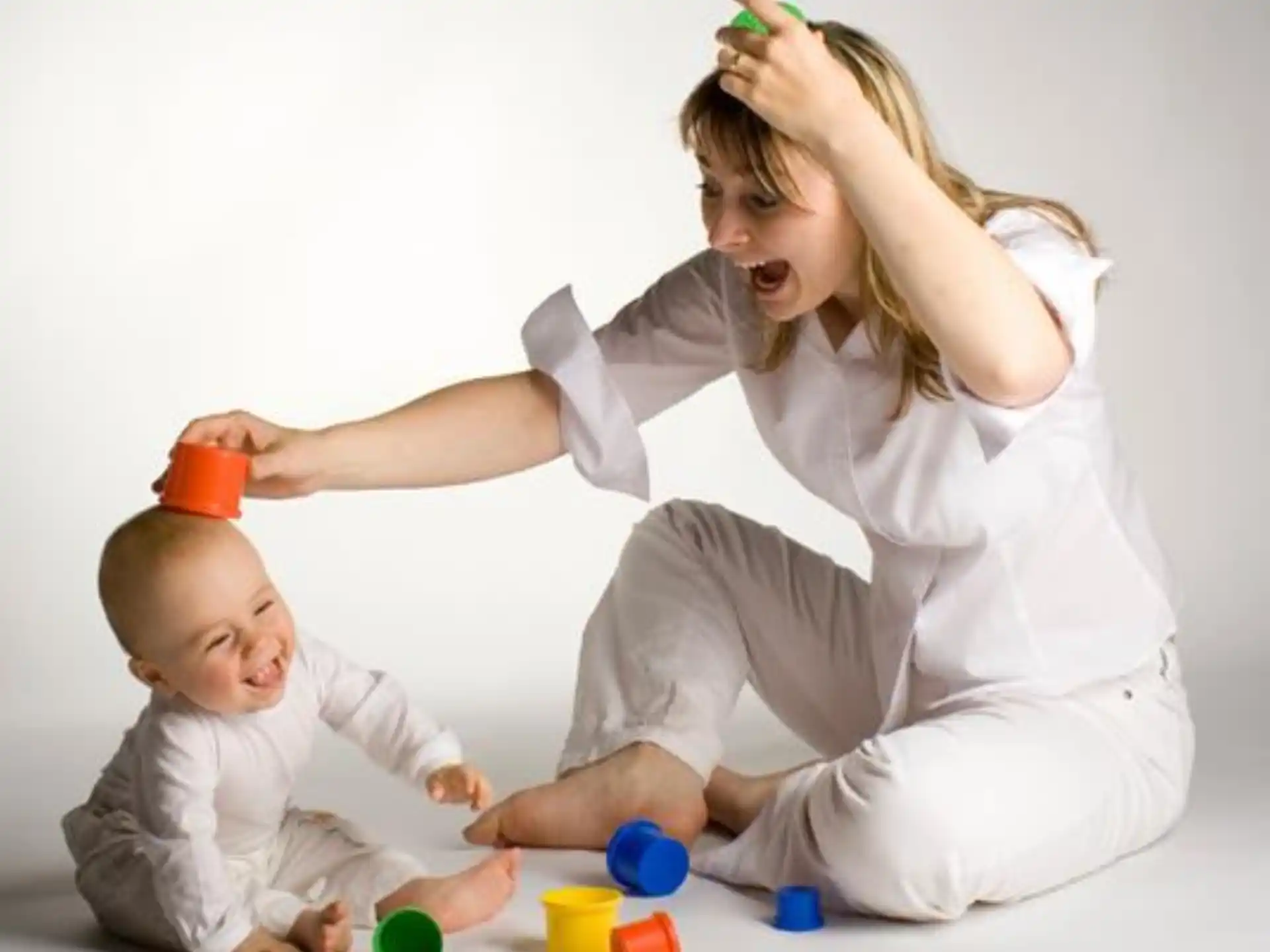 a woman playing with a baby