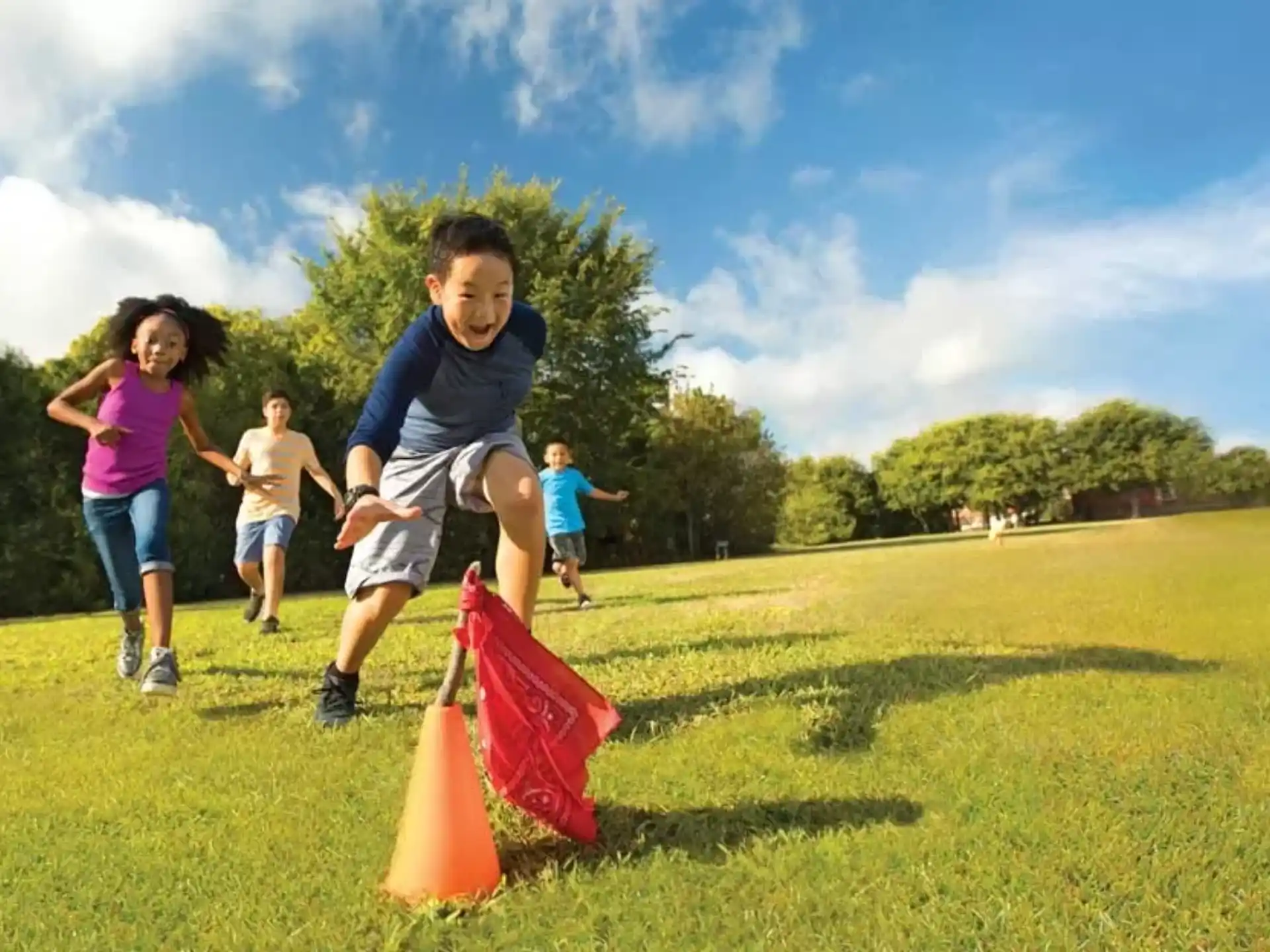a group of kids playing in a grassy field