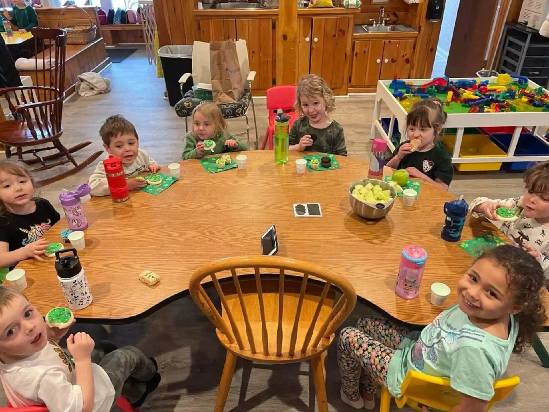 a group of children sitting around a table