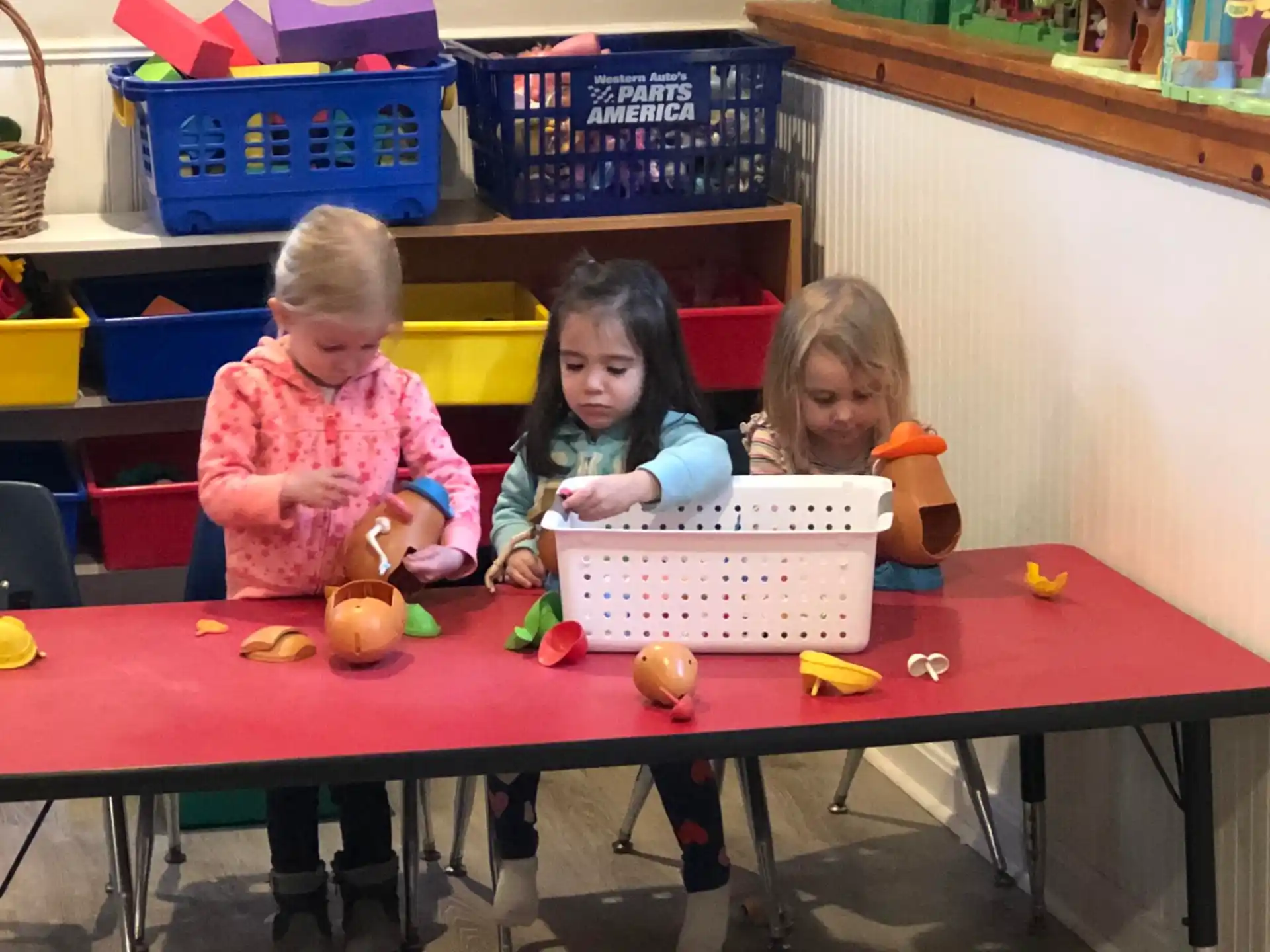 a group of children sitting at a table with baskets and baskets