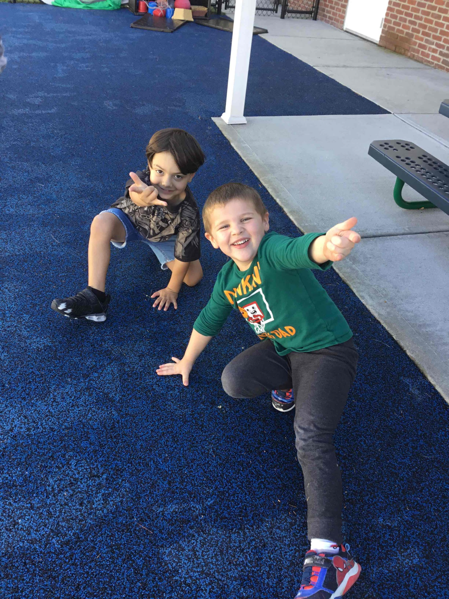 a couple of boys sitting on the ground posing for the camera