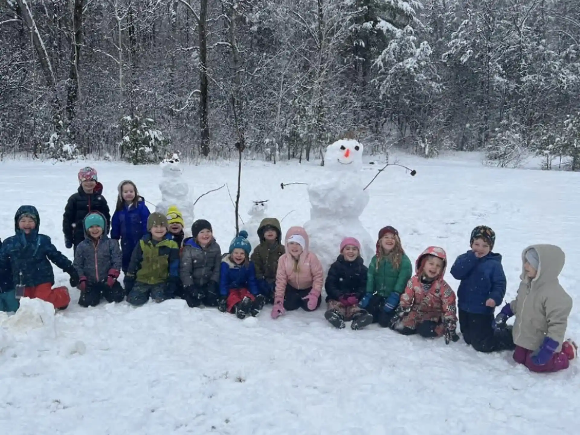 a group of people sitting in the snow