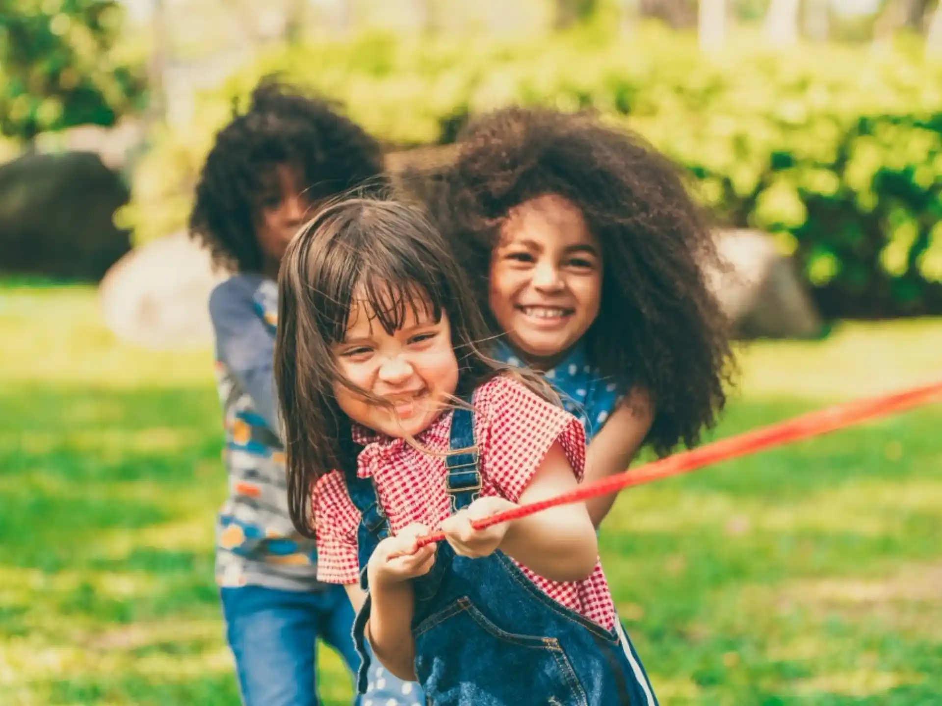 a group of children playing with a rope