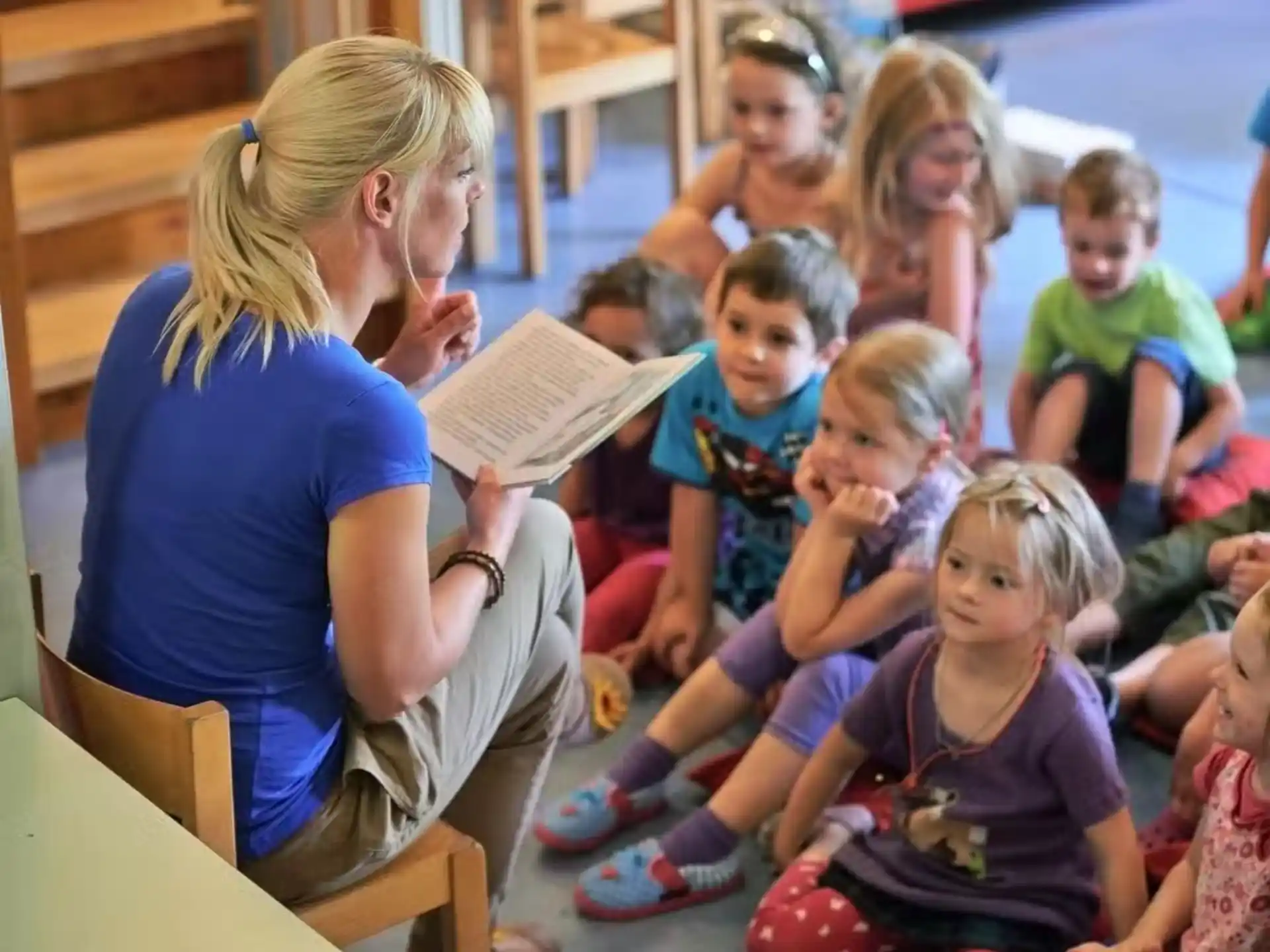 a person reading a book to a group of children