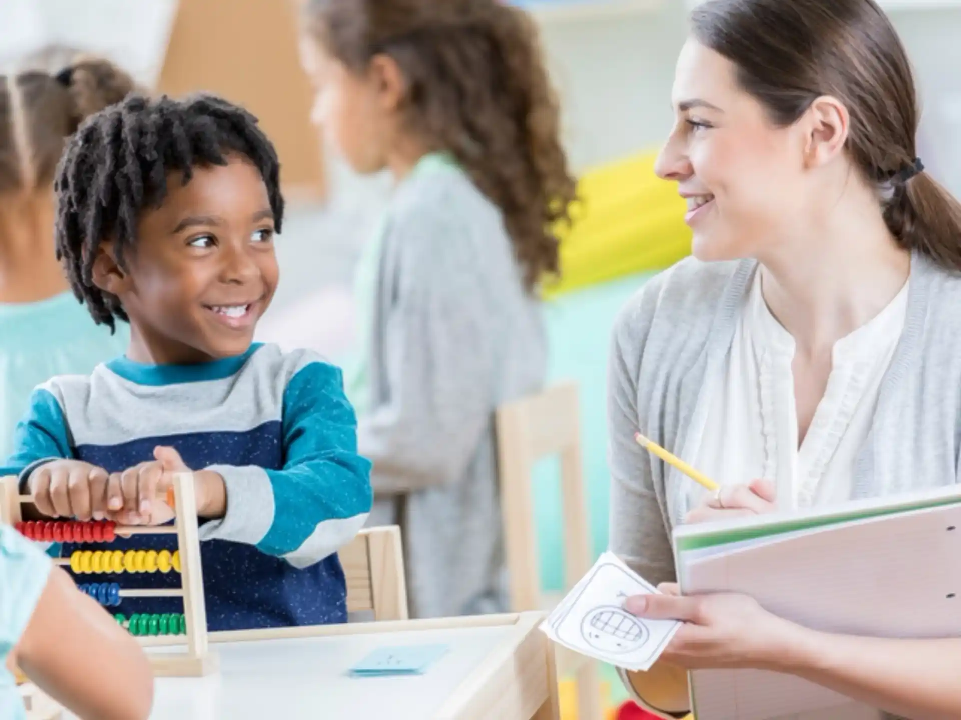 a teacher showing her student something on the tablet