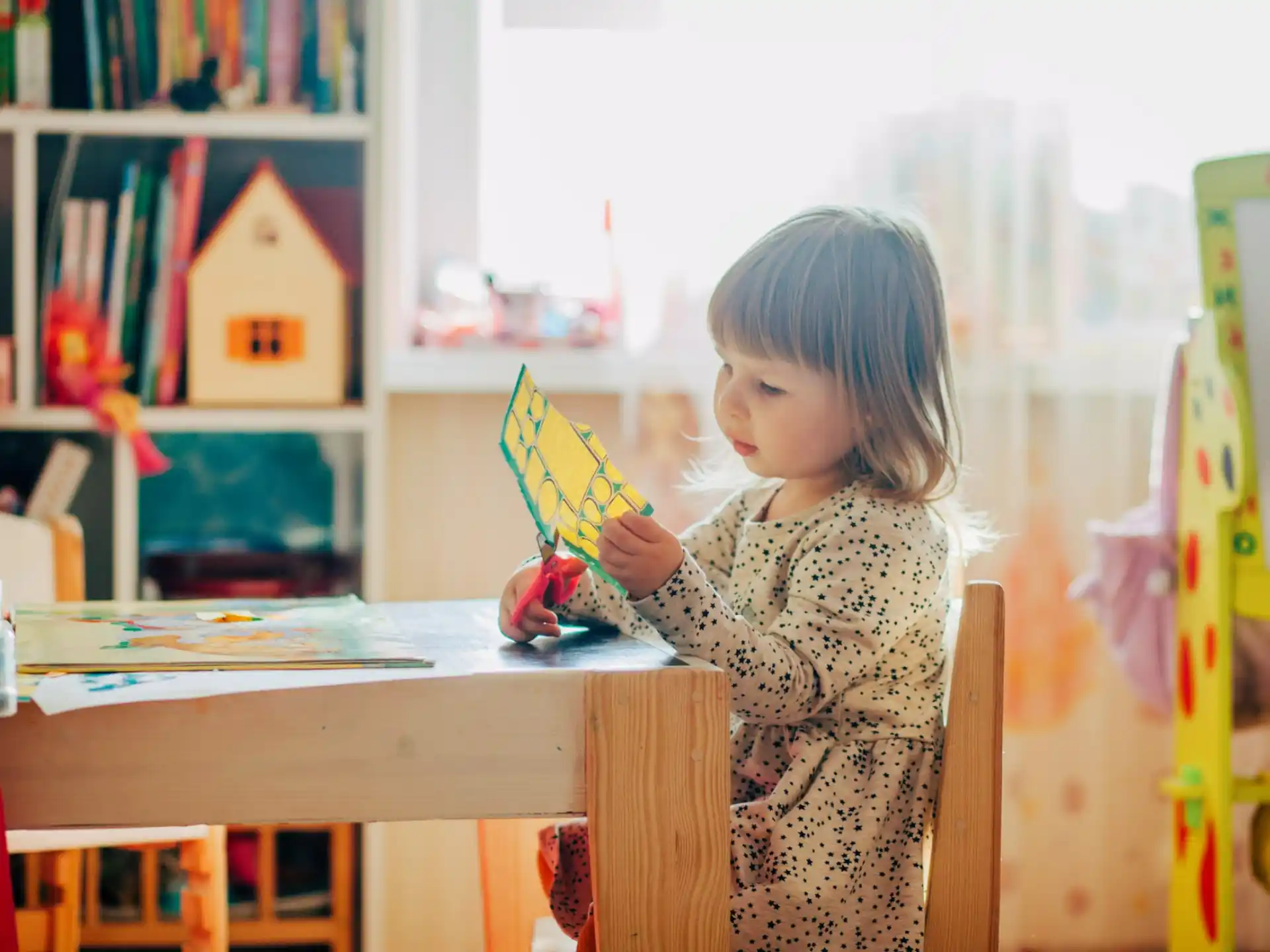 a little girl holding a yellow and blue umbrella