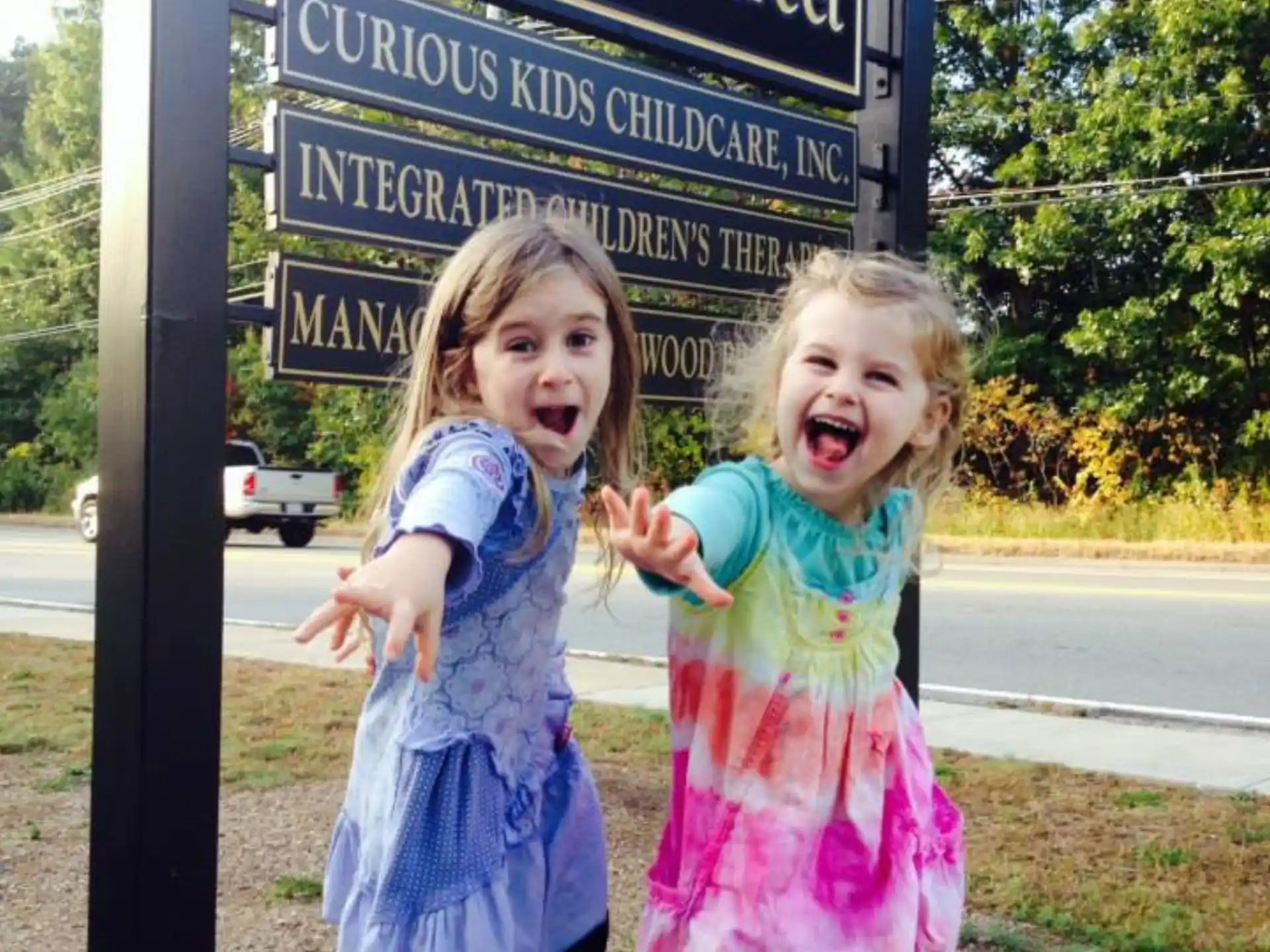 two girls standing in front of a sign