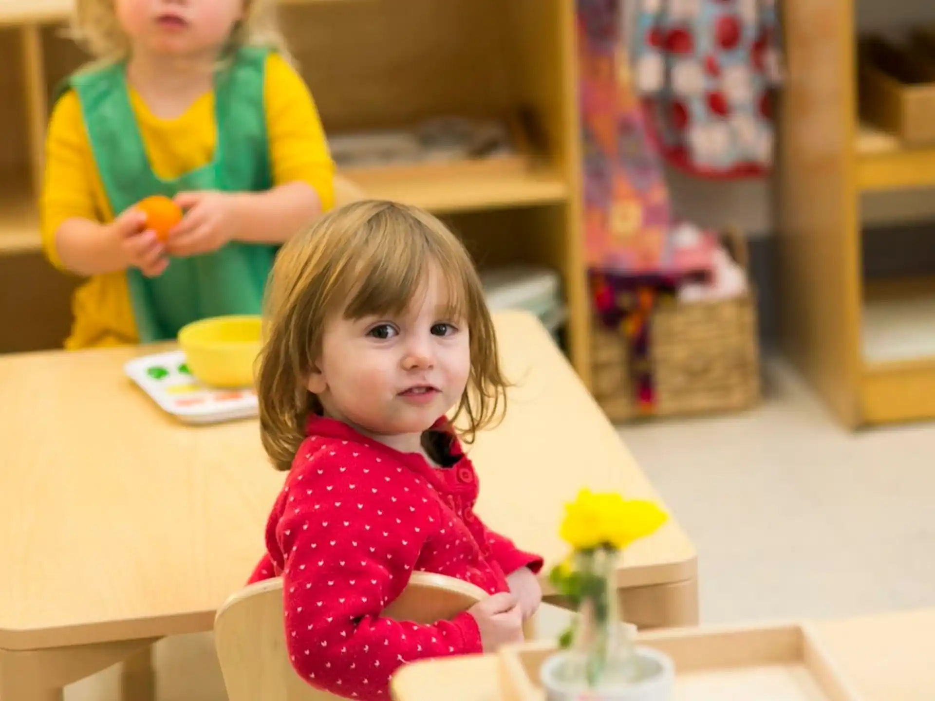 a little girl sitting at a table