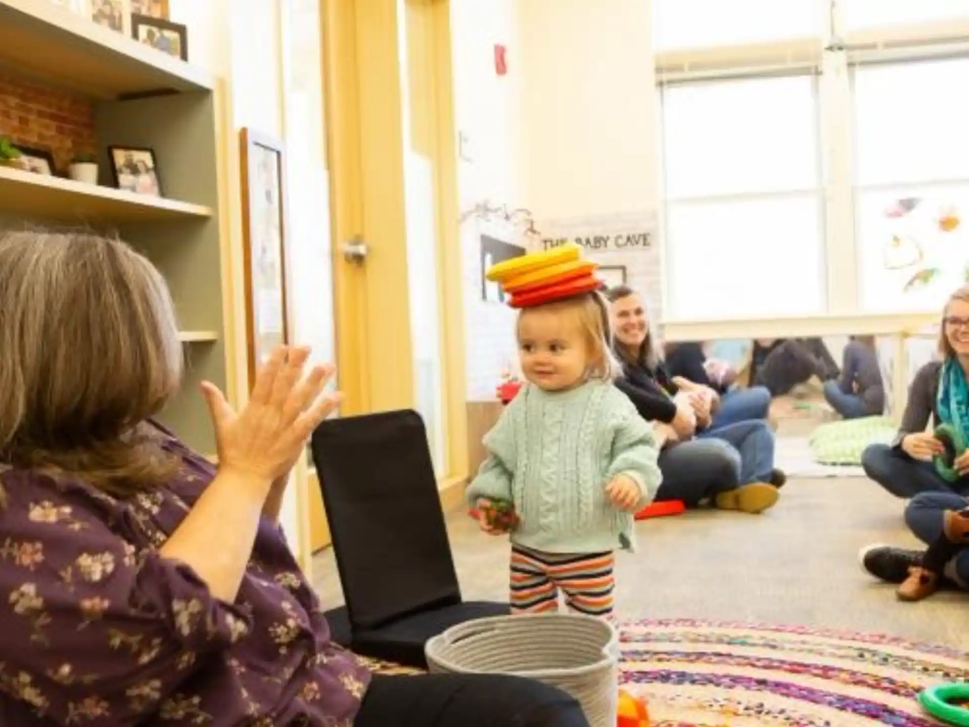 a person and a child in a room with a laptop