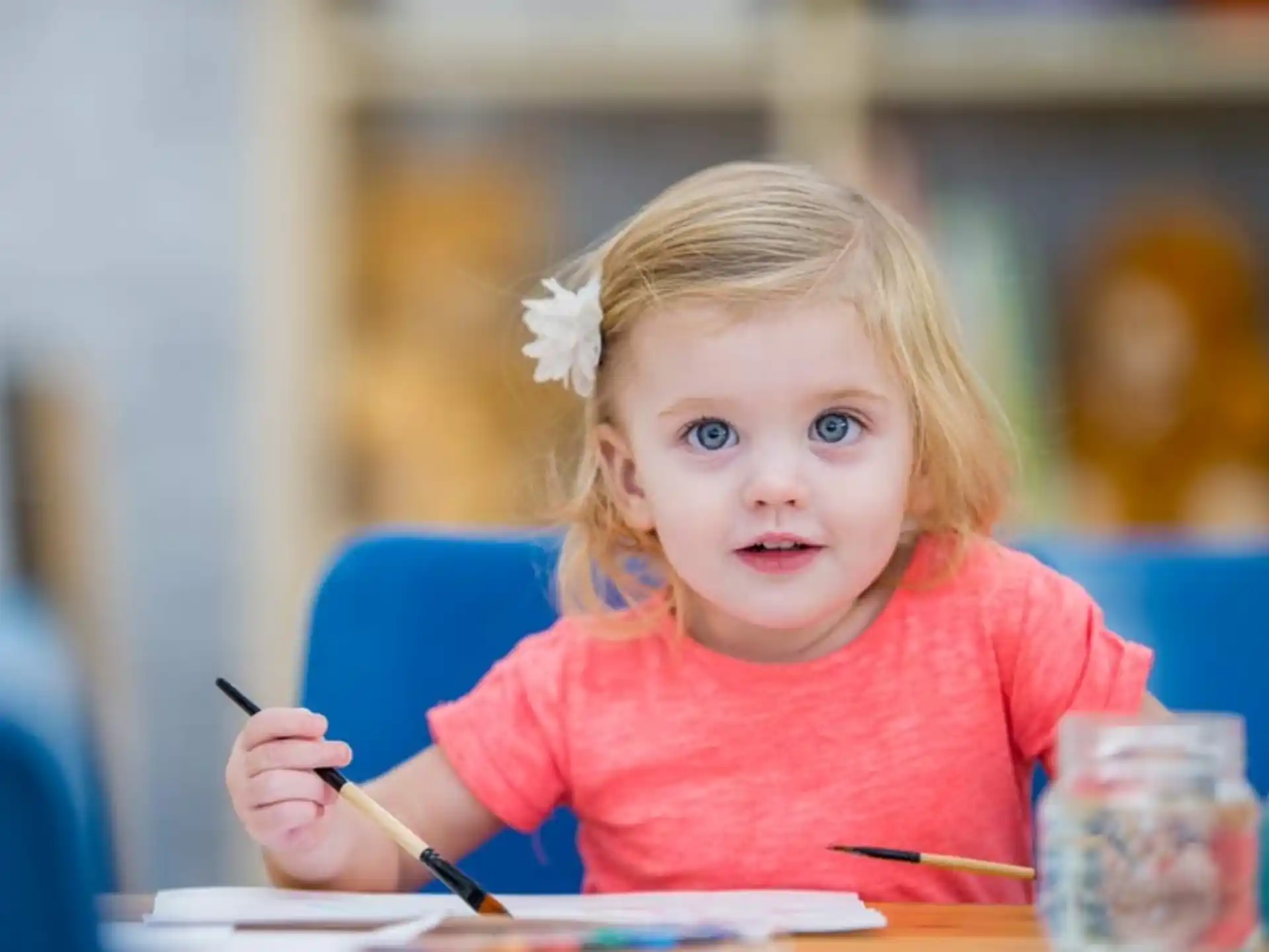 a little girl sitting at a table