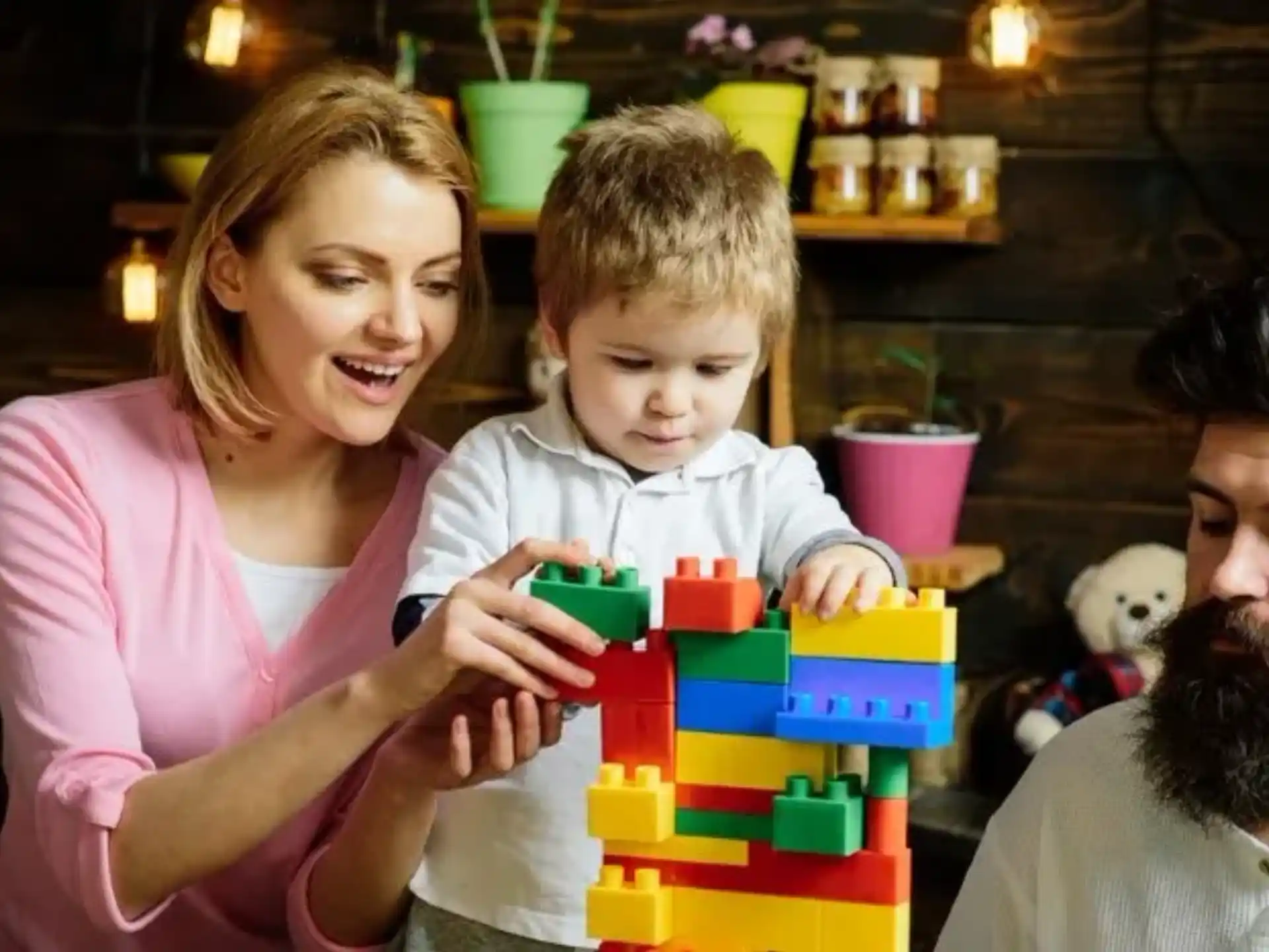 a man and woman with a child playing with a toy