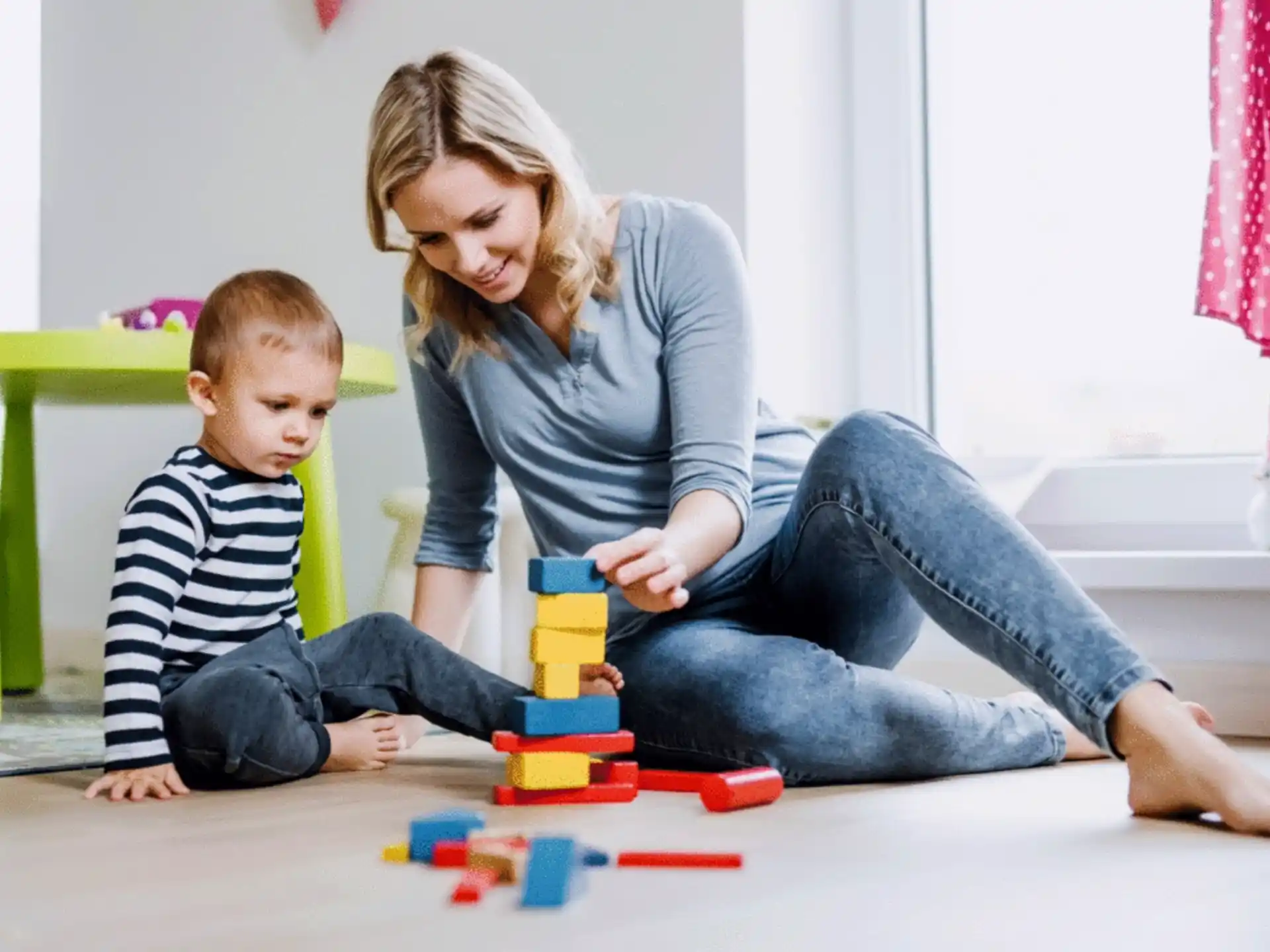 a person and a child playing with toys on the floor