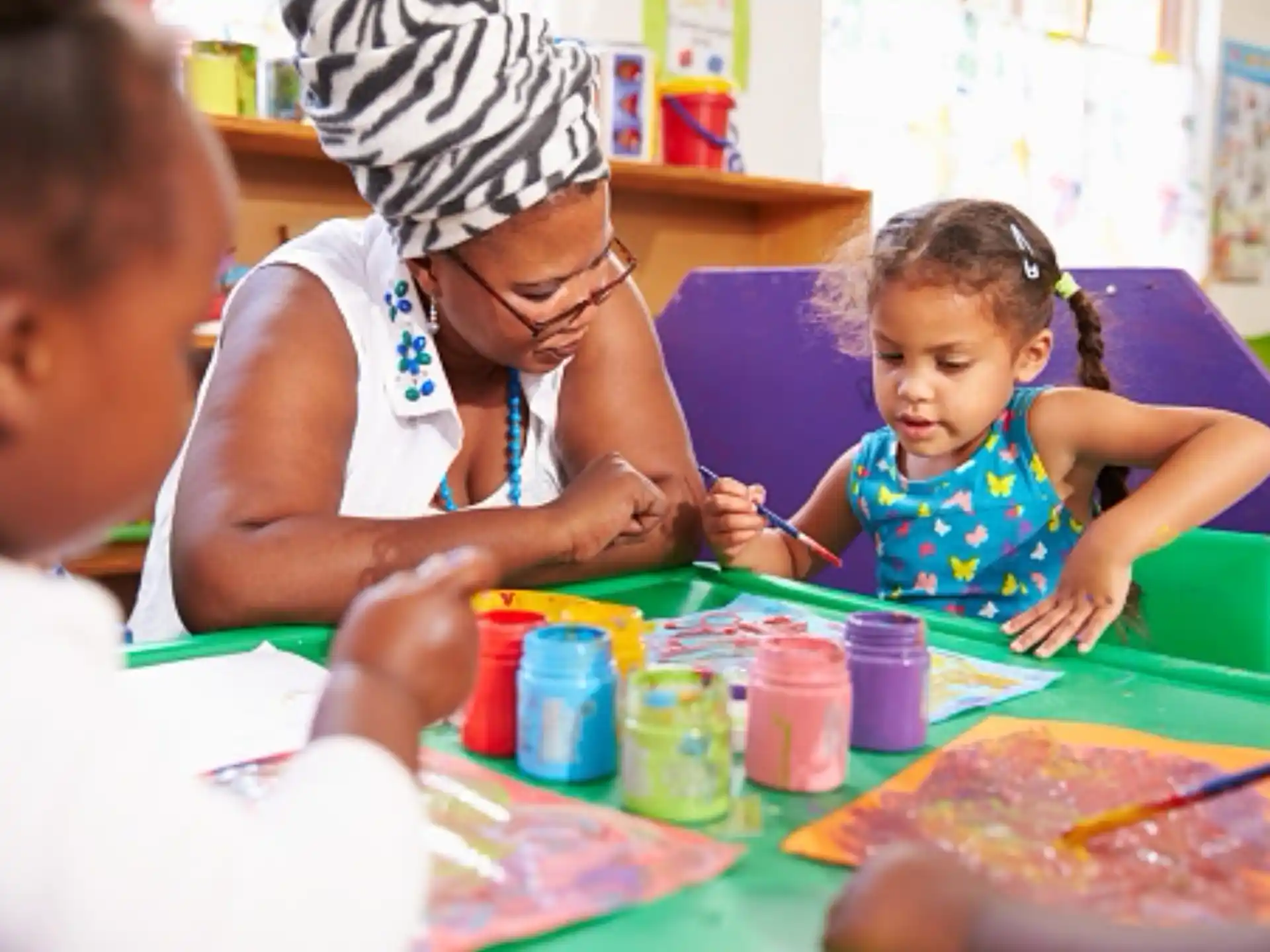 a person and a few children painting