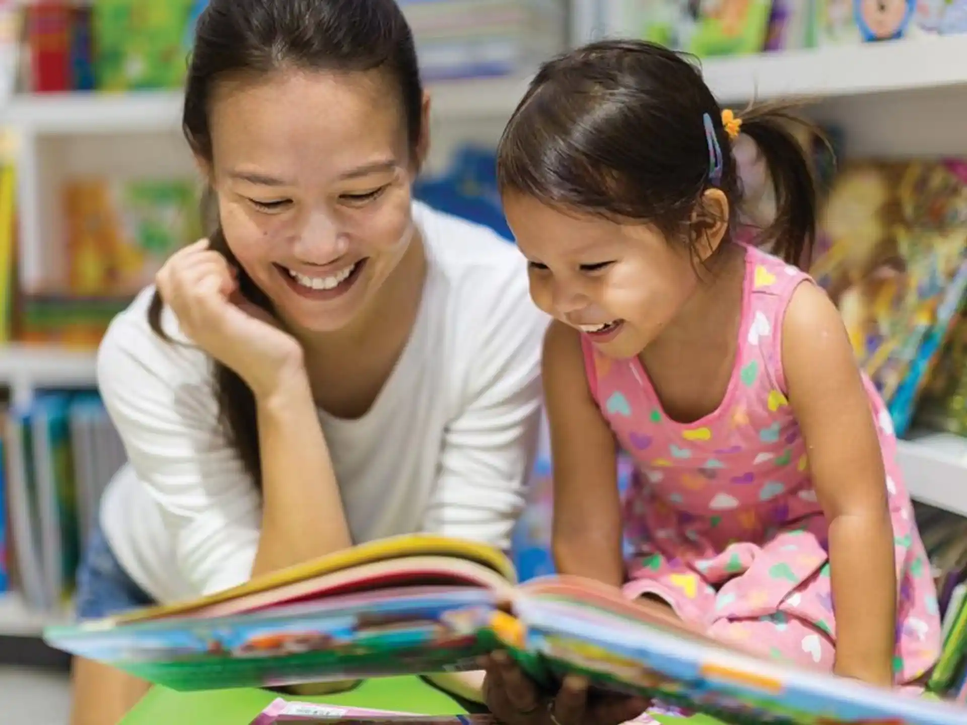 a person and a girl looking at a book