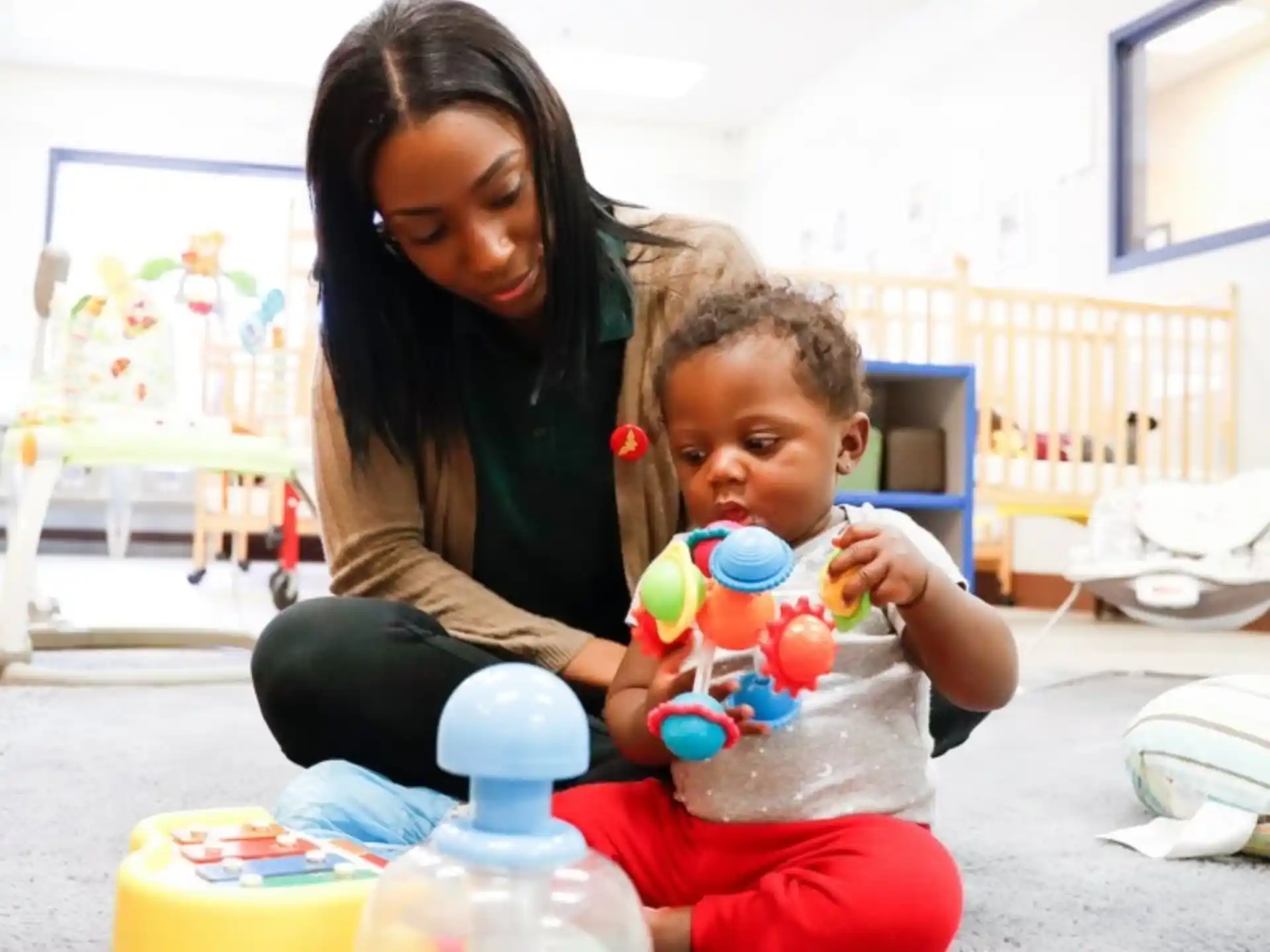 a person and a child playing with toys in a room