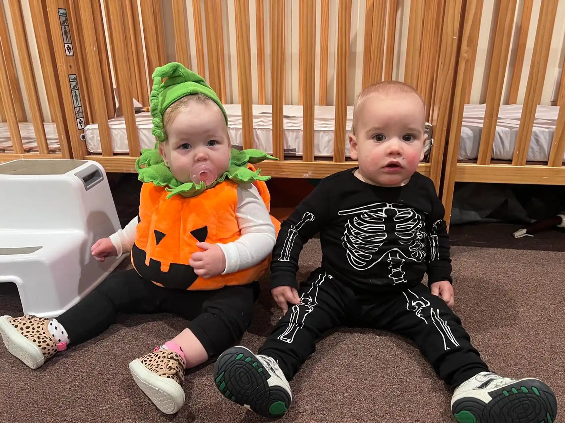 two babies sitting on the floor