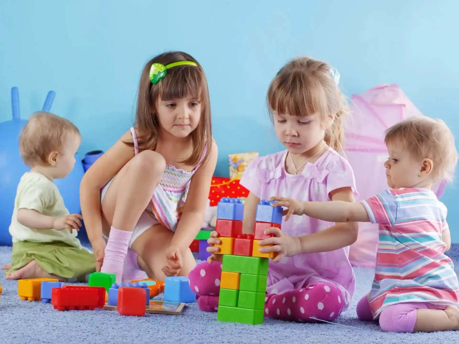 a group of children sitting on the floor with toys