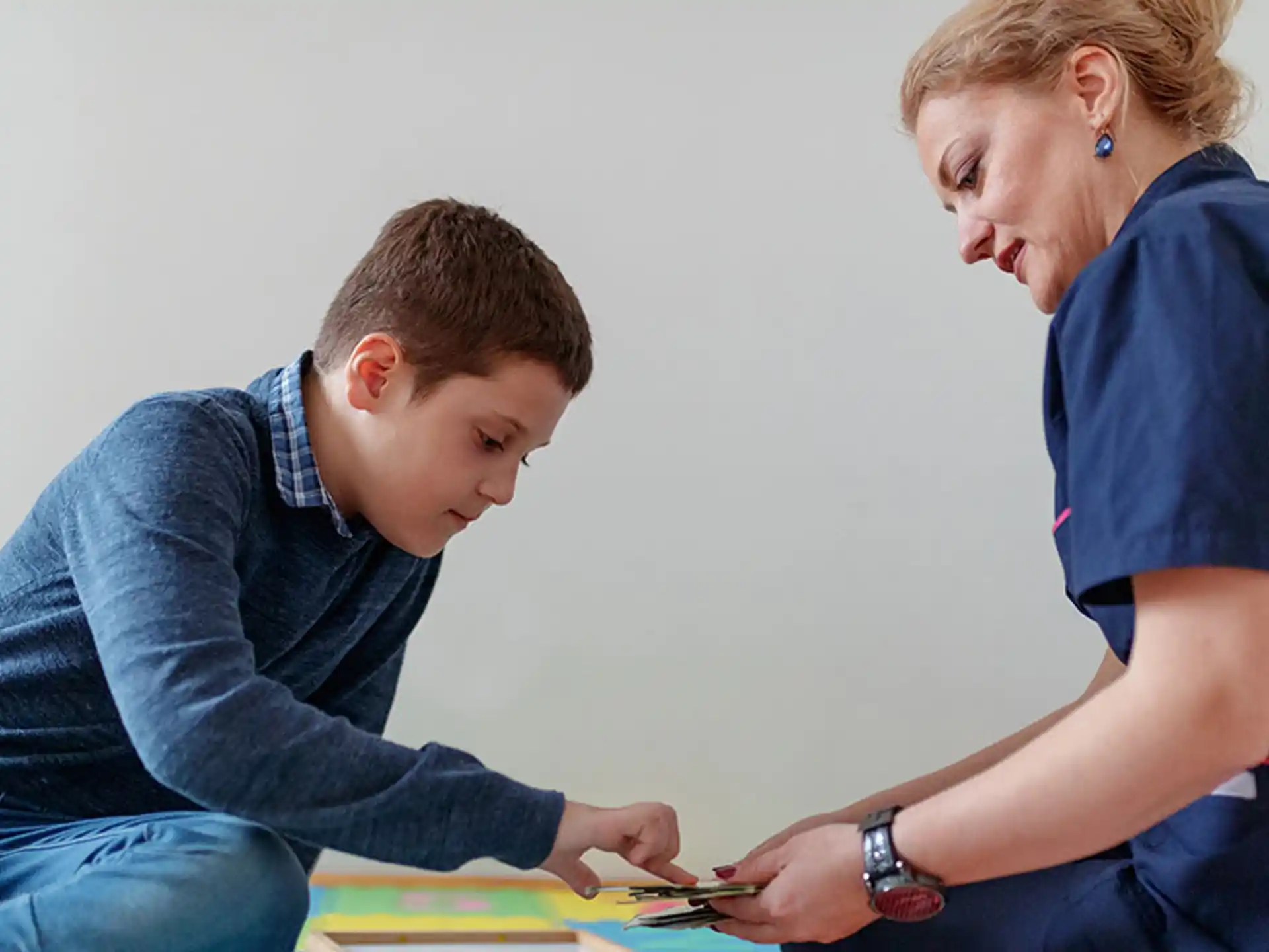 a person and a boy looking at a paper