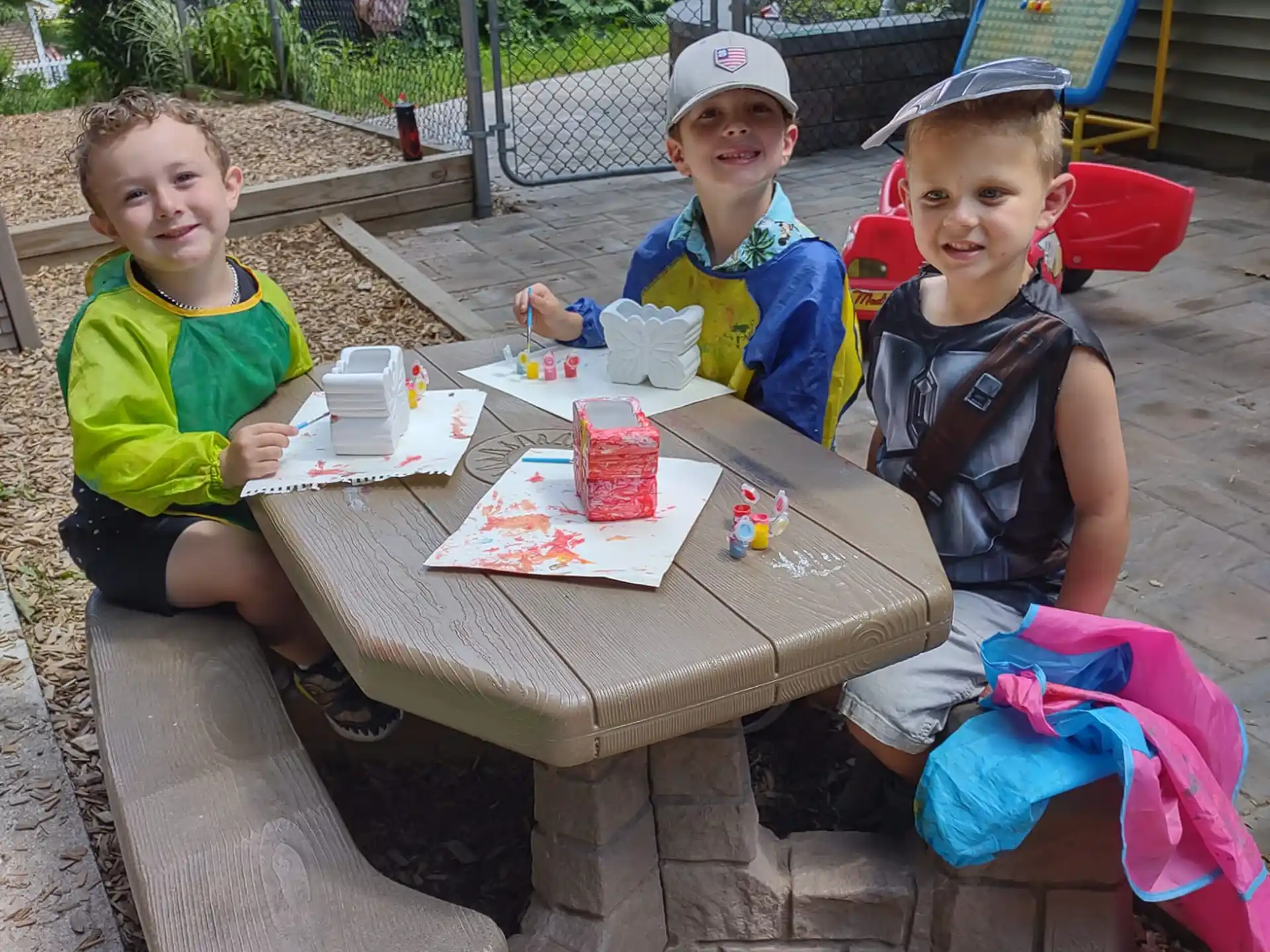 a group of kids sitting at a table outside