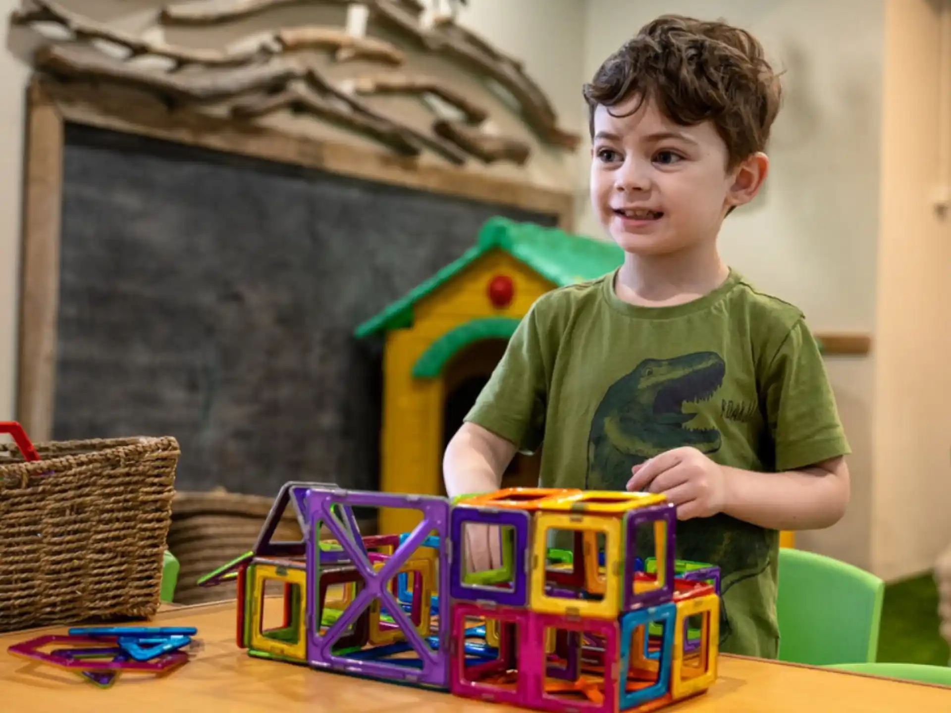 a boy sitting at a table with a toy train