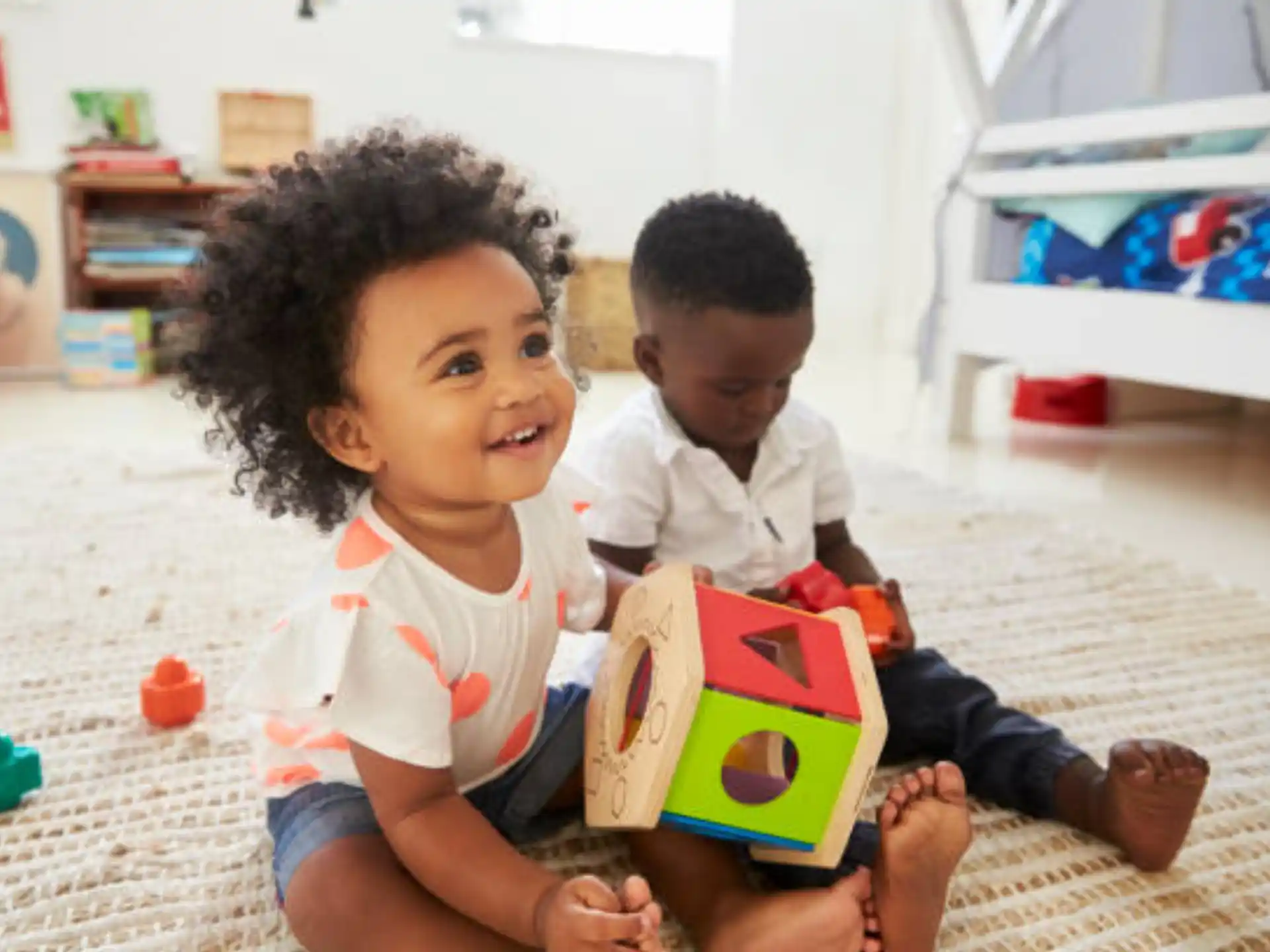a couple of children sitting on the floor reading a book