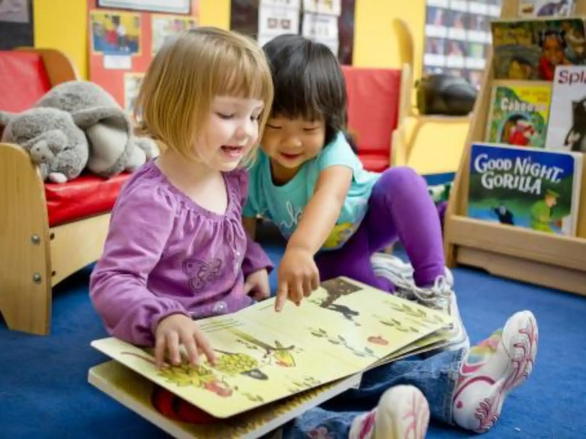 a couple of young girls reading a book