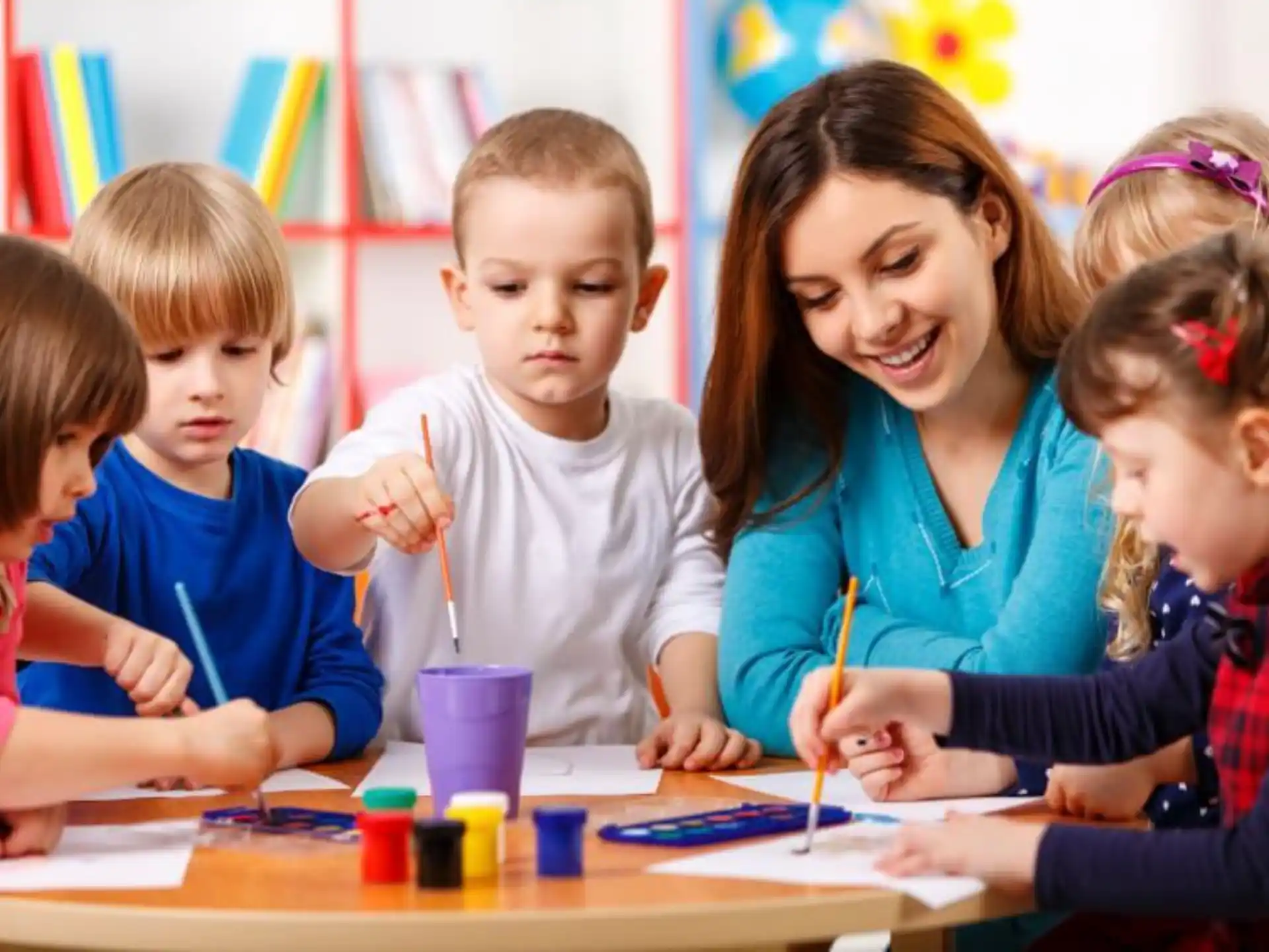 a person and several children painting
