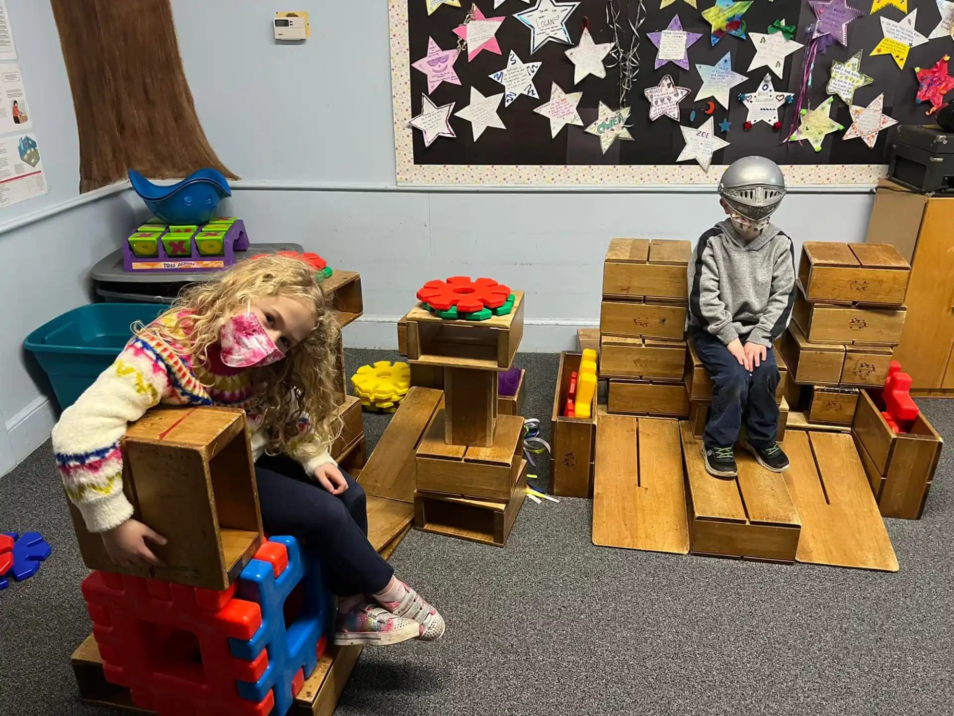 a child and a person sitting on wooden blocks