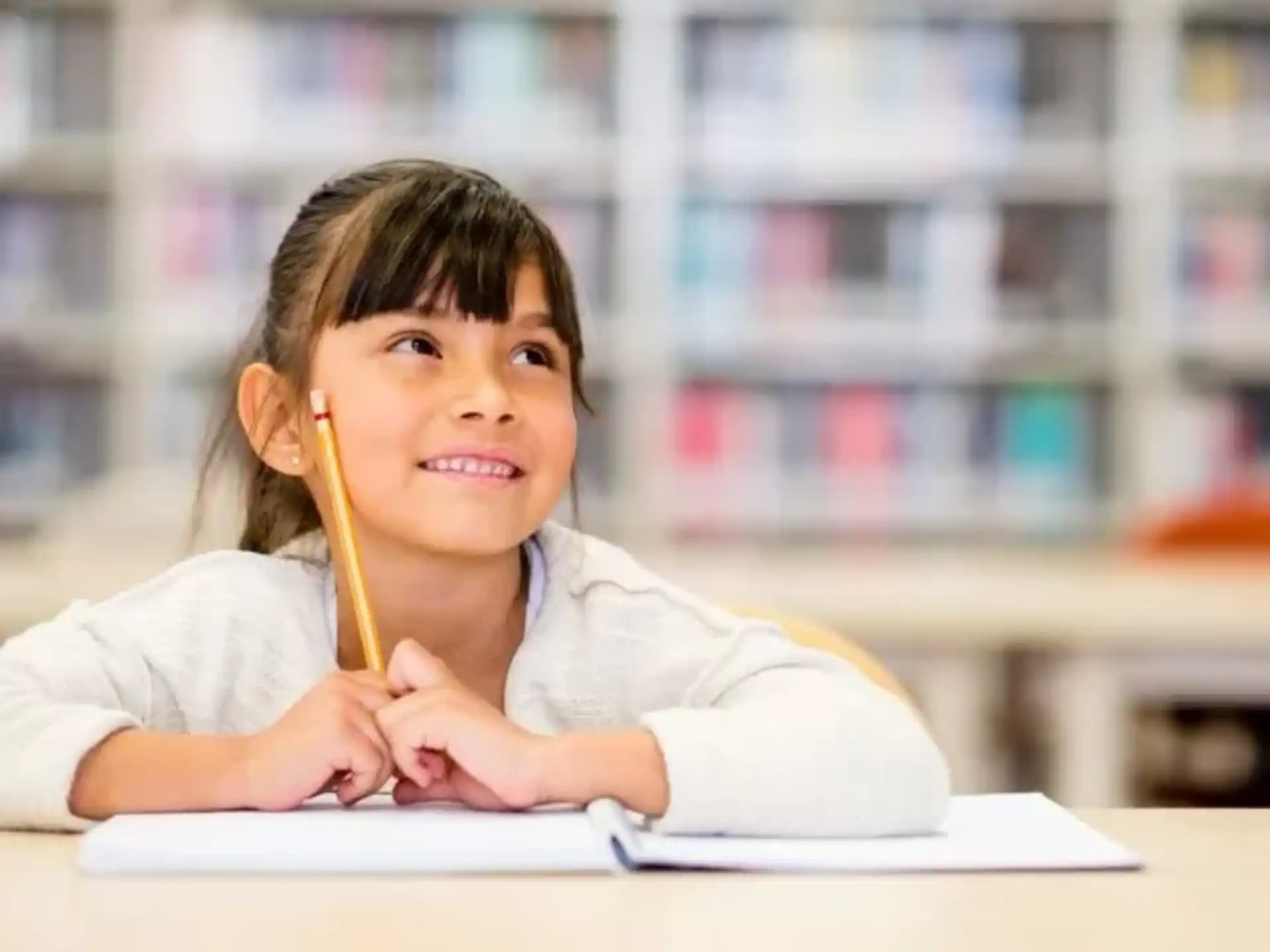 a young girl sitting at a desk