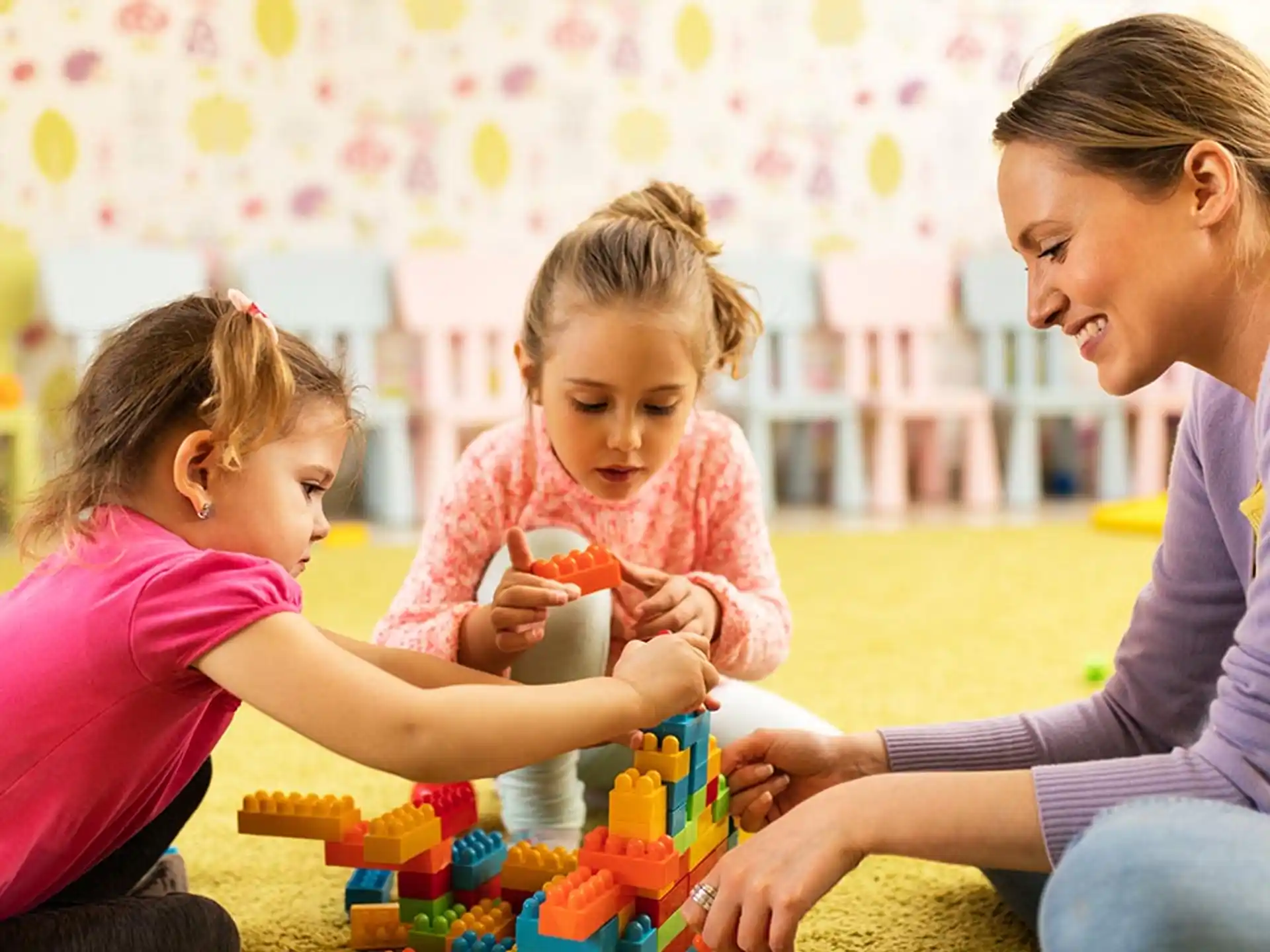 a woman and two children playing with toys
