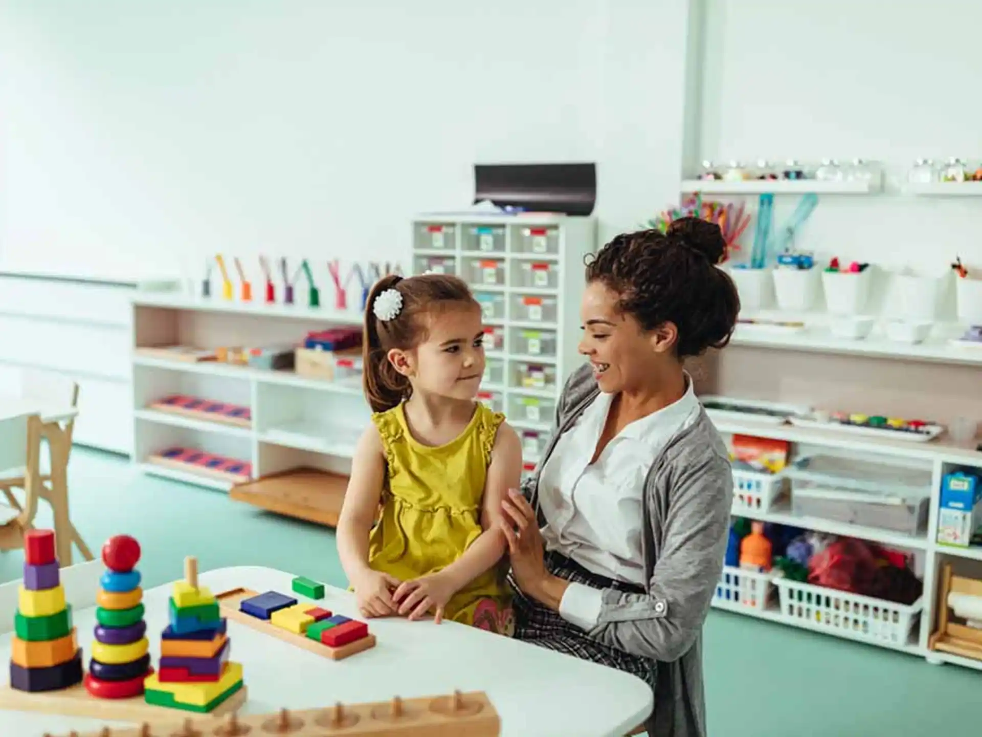 a person and a child sitting at a table with a cake