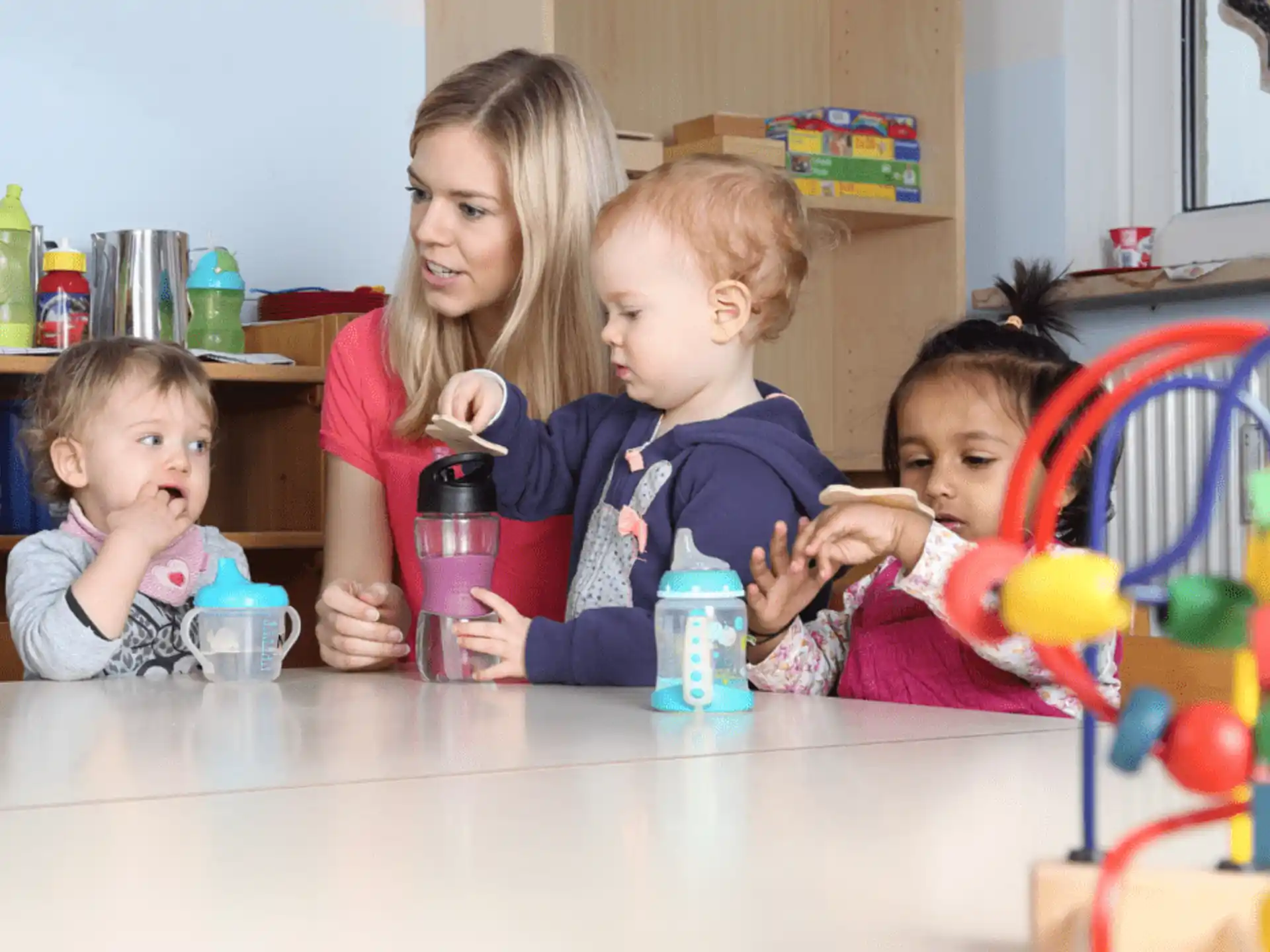 a person and two children sitting at a table with a toy