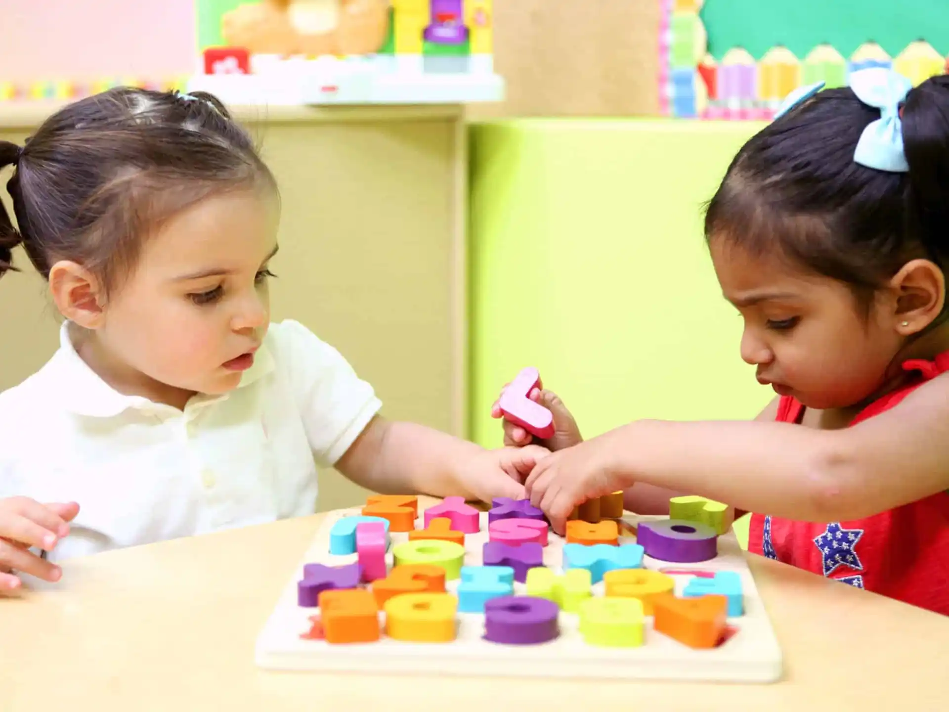 a couple of young girls playing with blocks
