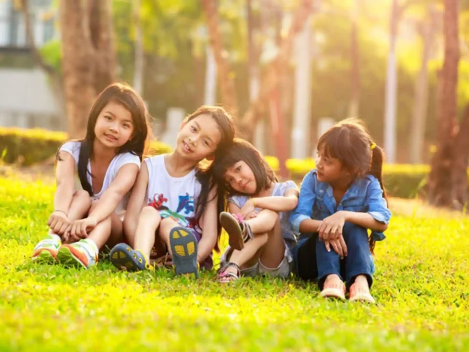 a group of girls sitting in the grass