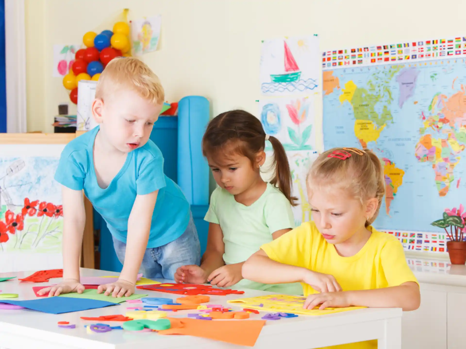 a group of children sitting at a table with a map