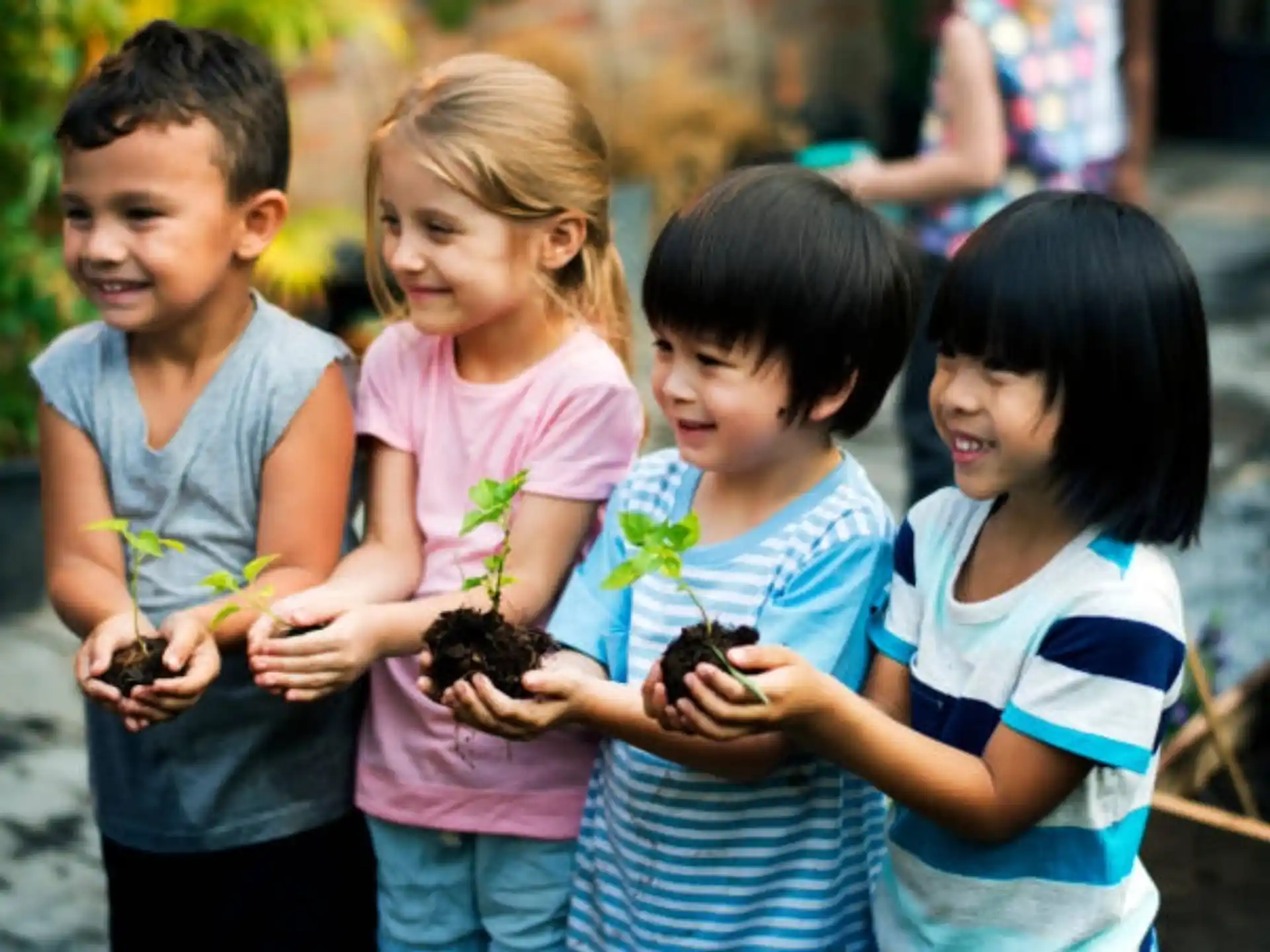 a group of children holding small plants