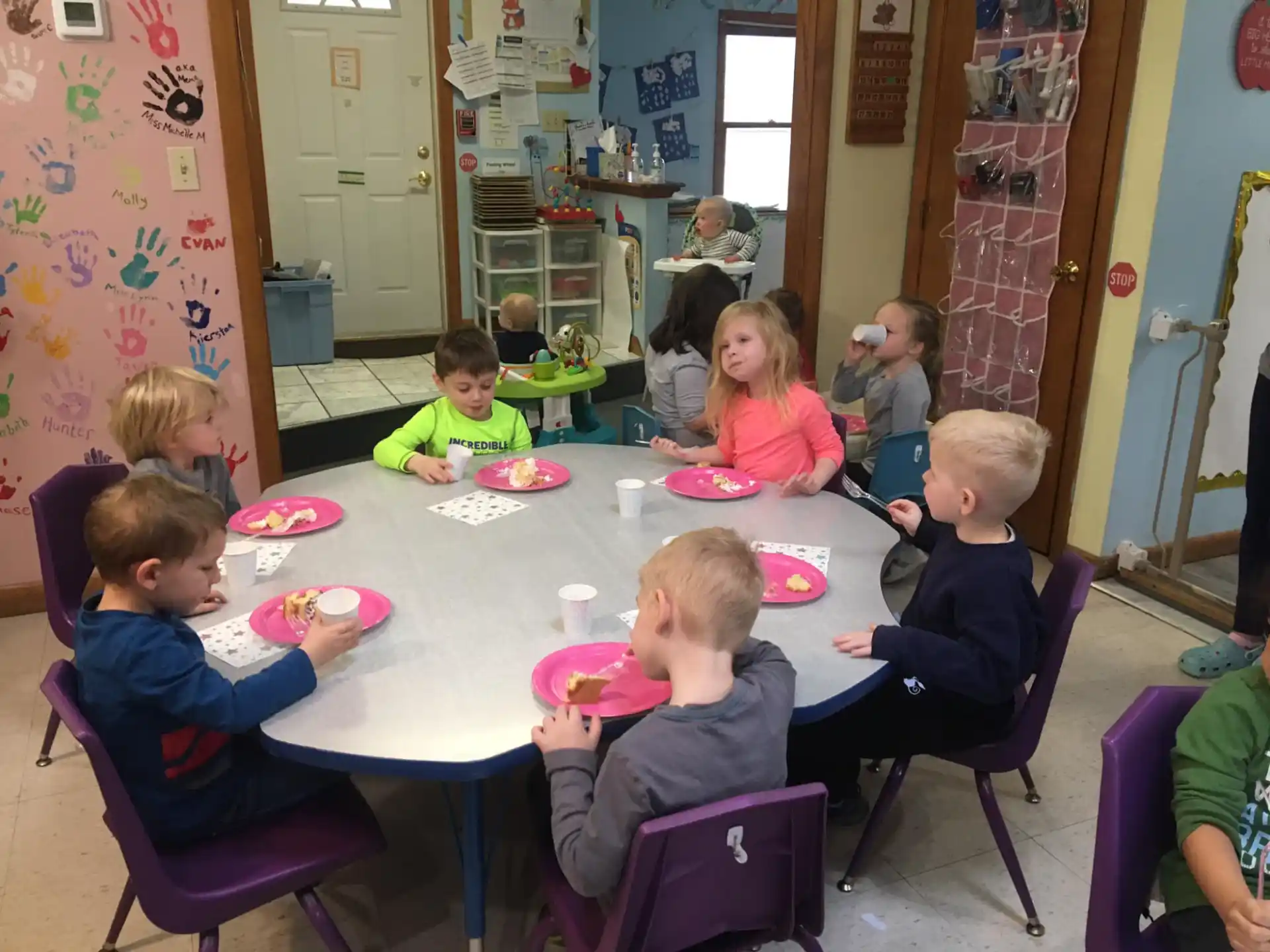 a group of children eating at a table
