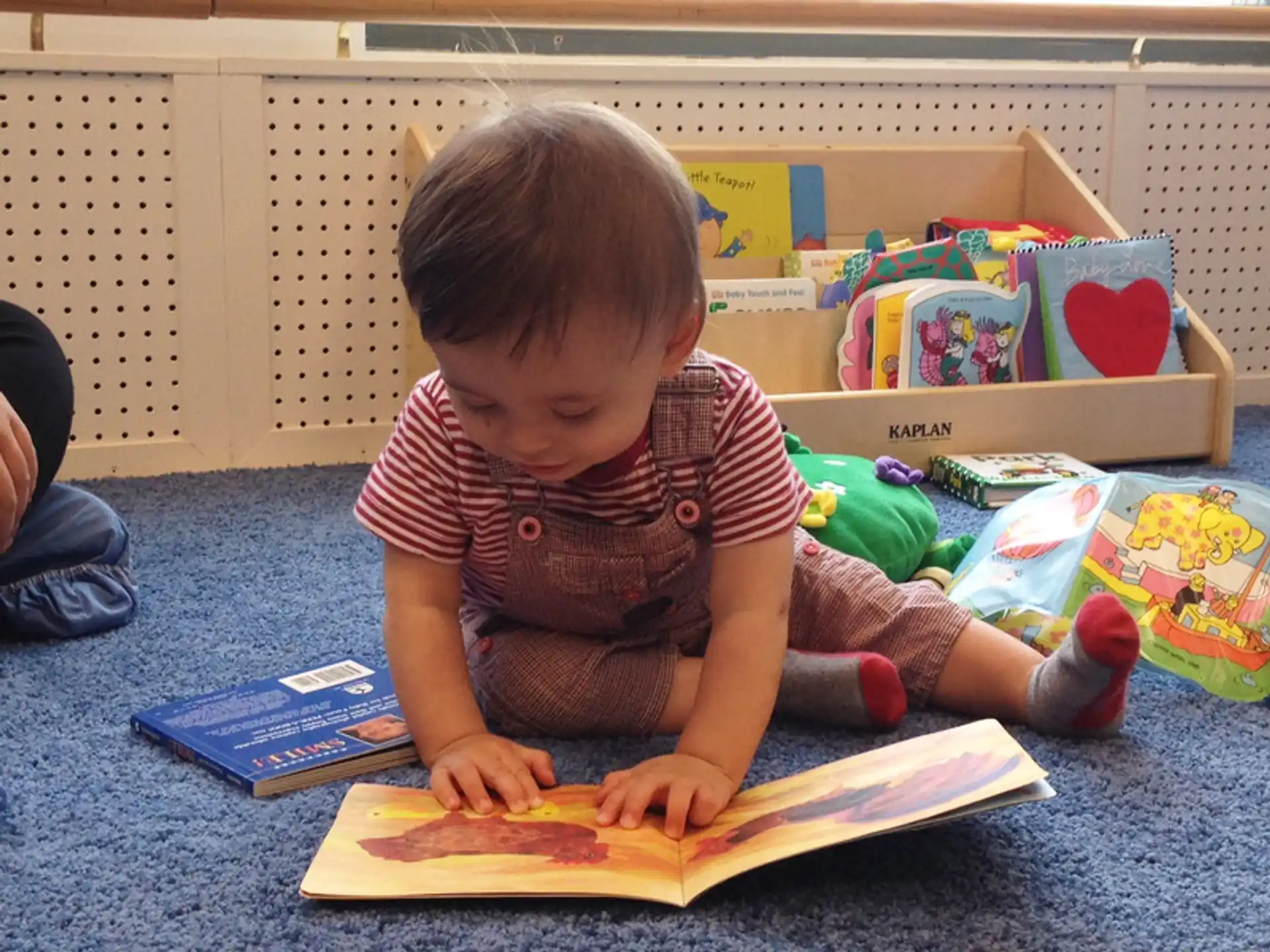 a child sitting on the floor reading a book