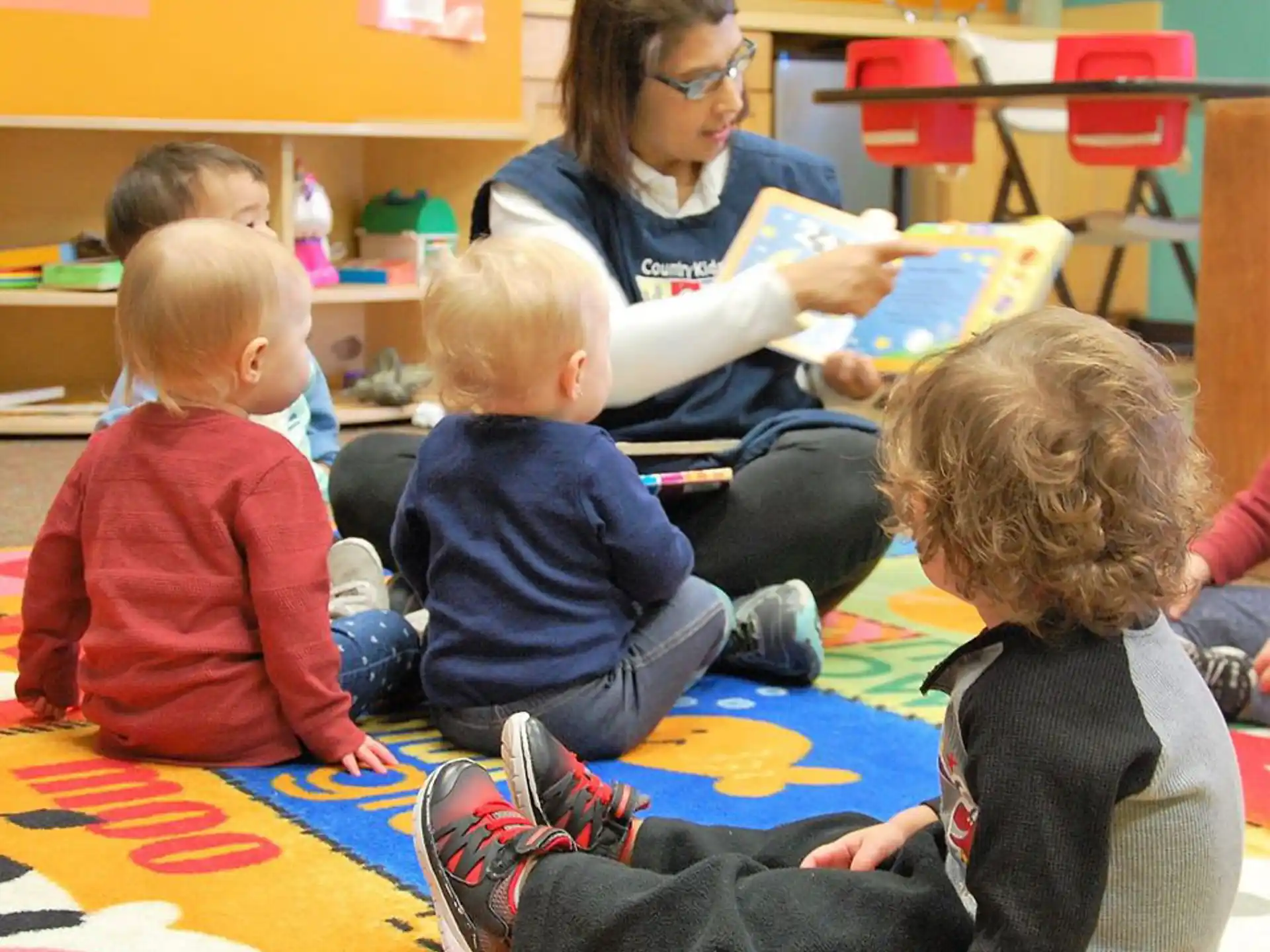 a person reading a book to several children