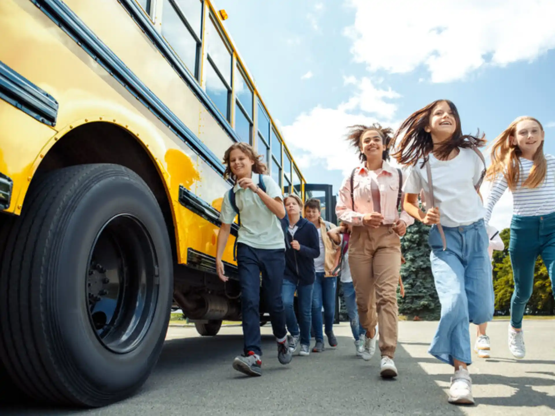 a group of people walking next to a yellow school bus