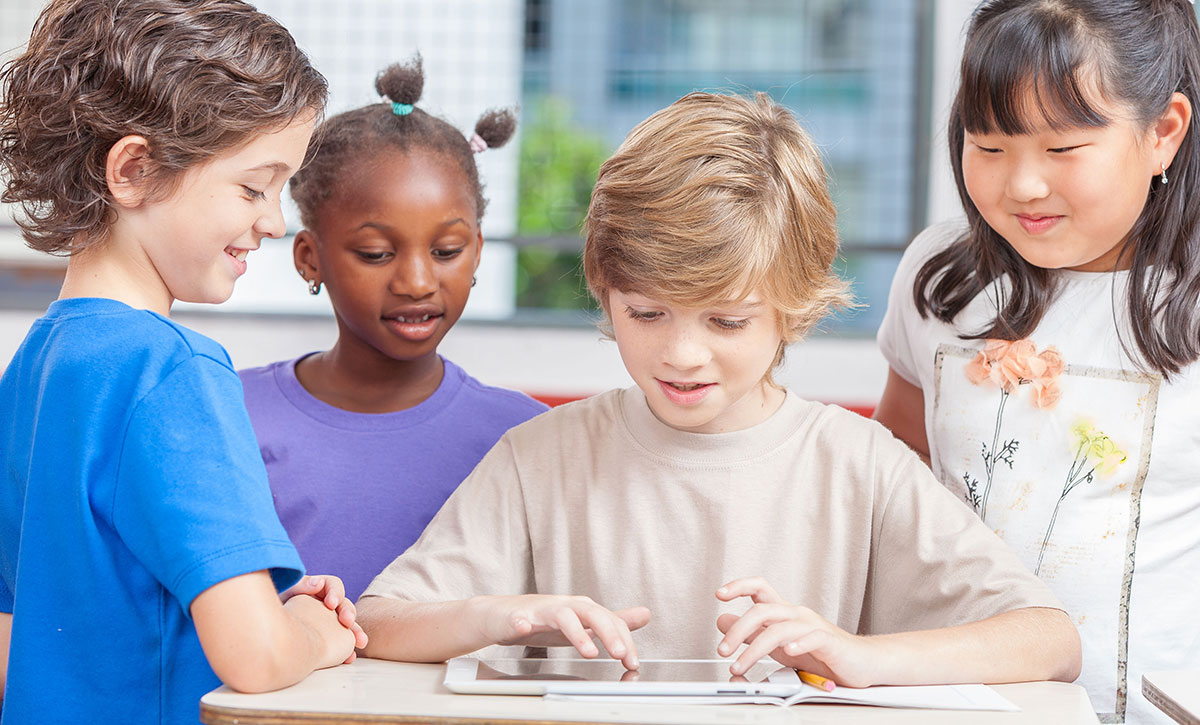 a group of children looking at a tablet