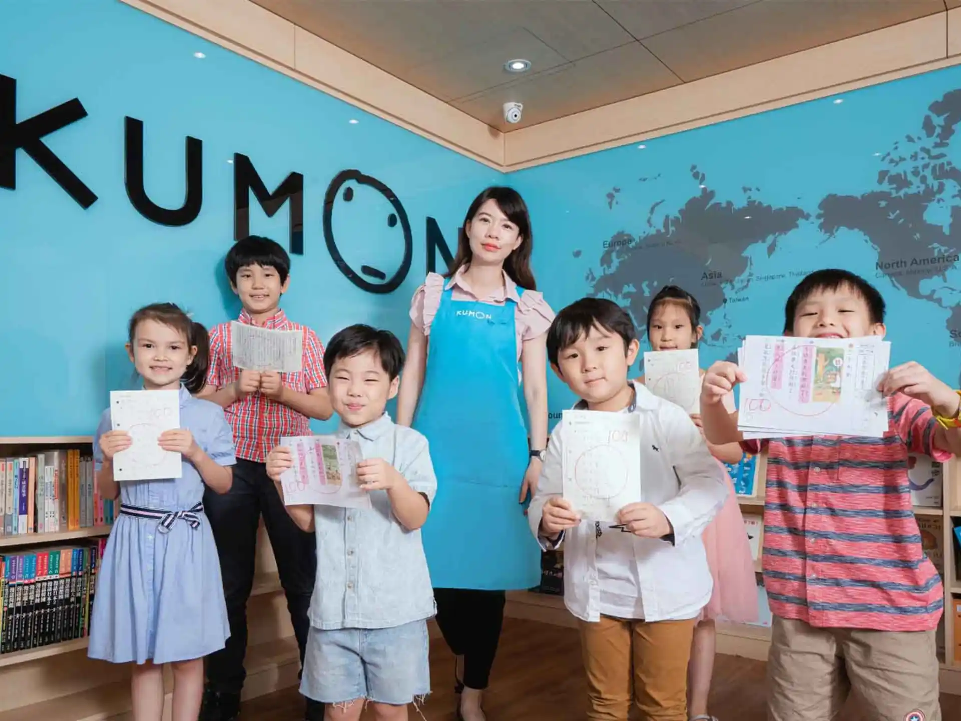 a group of children holding up a piece of paper