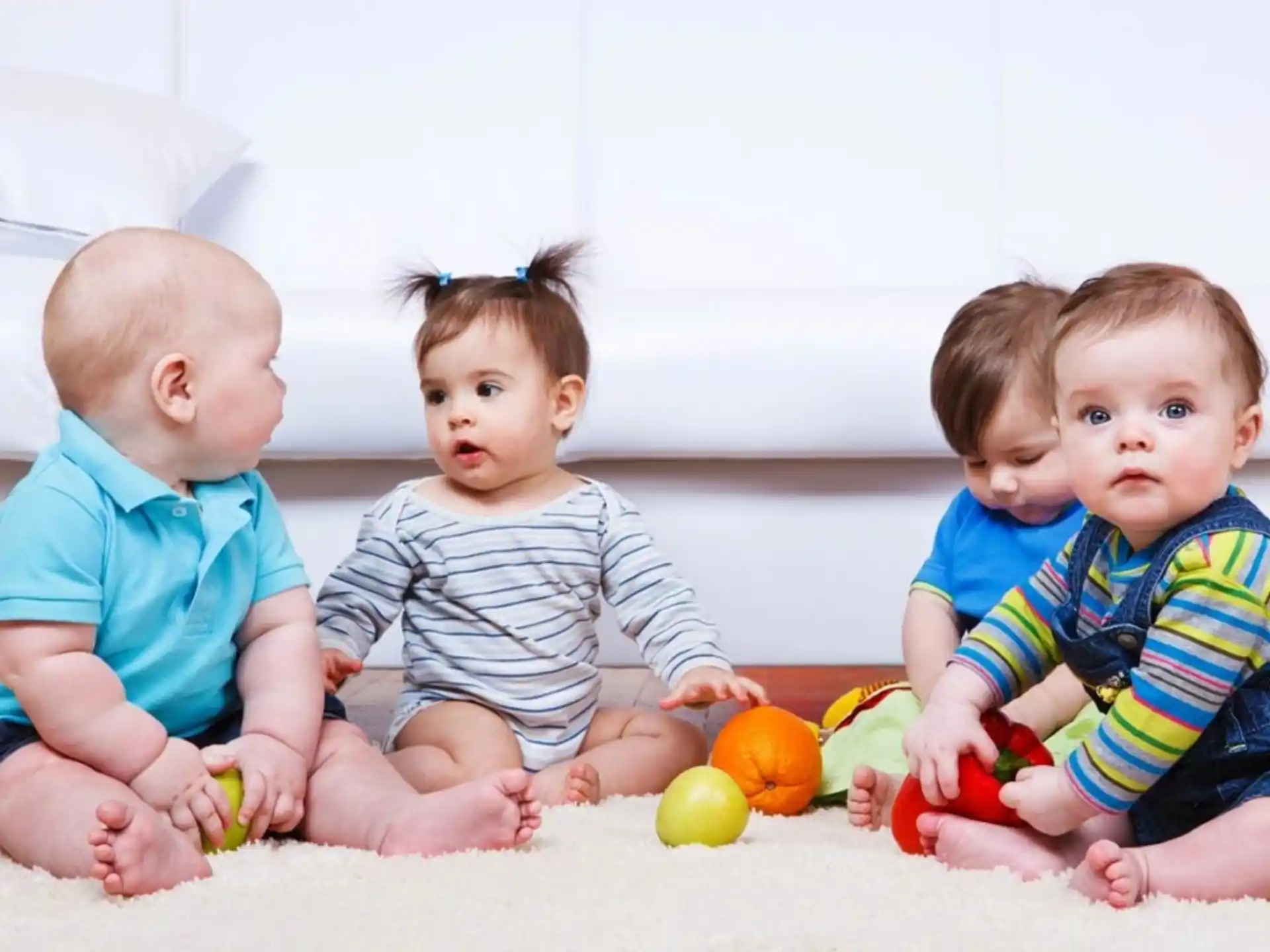a group of babies sitting on the floor