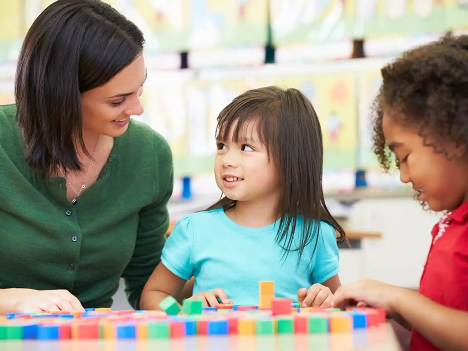 a person and a couple of children playing a board game