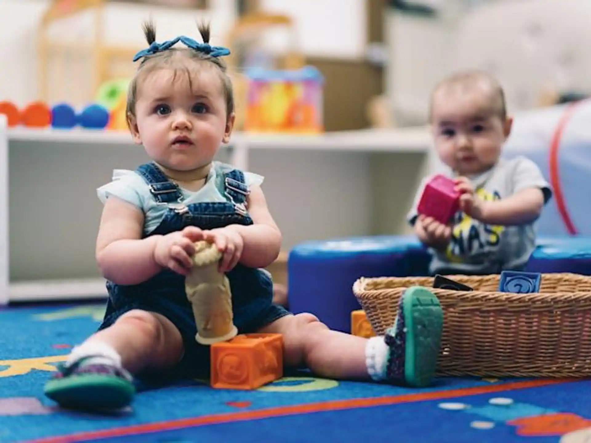 a couple of babies sitting on the floor
