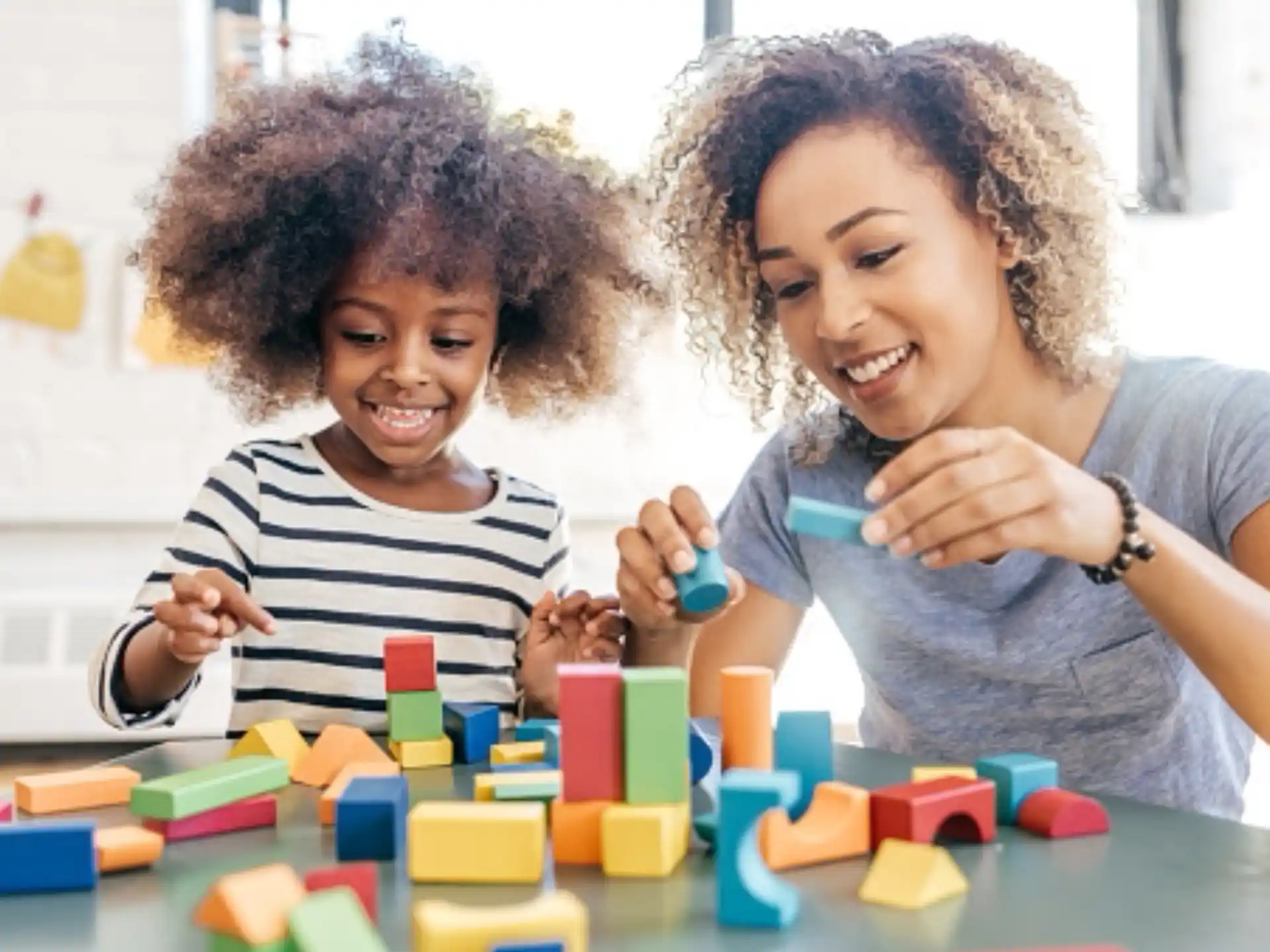 a person and a child playing with blocks
