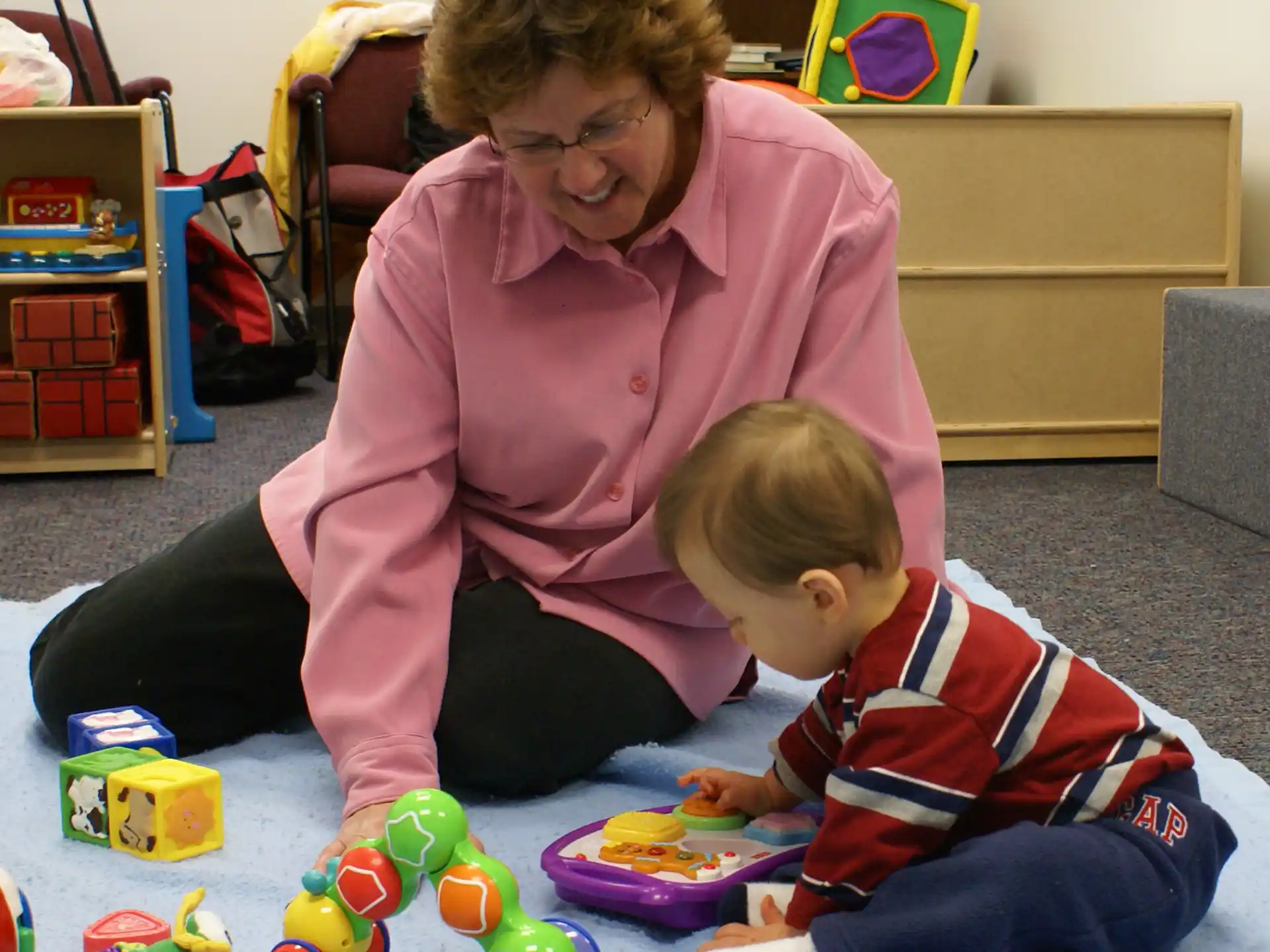 a person and a child playing with toys on the floor