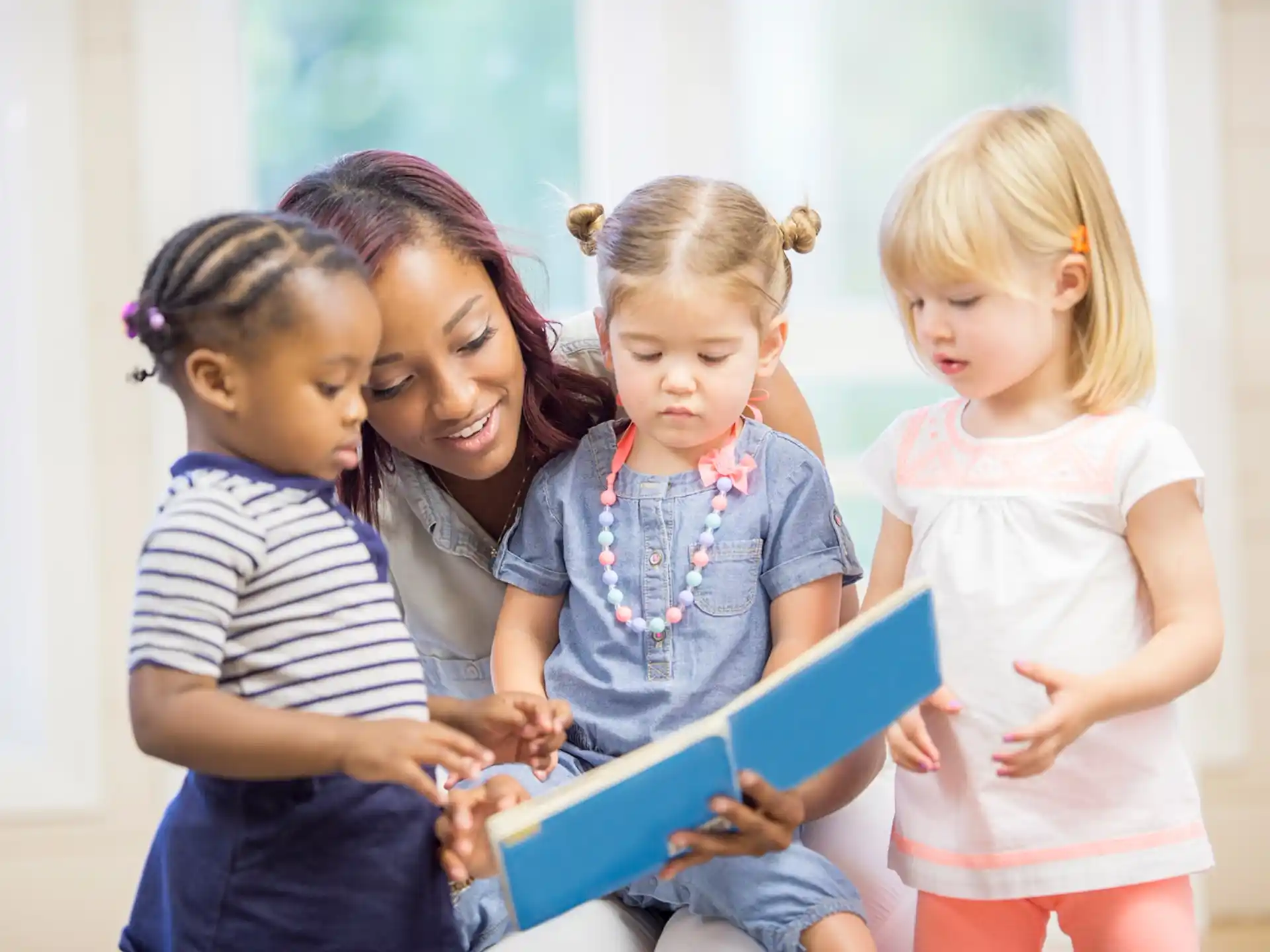 a person reading a book to a group of children