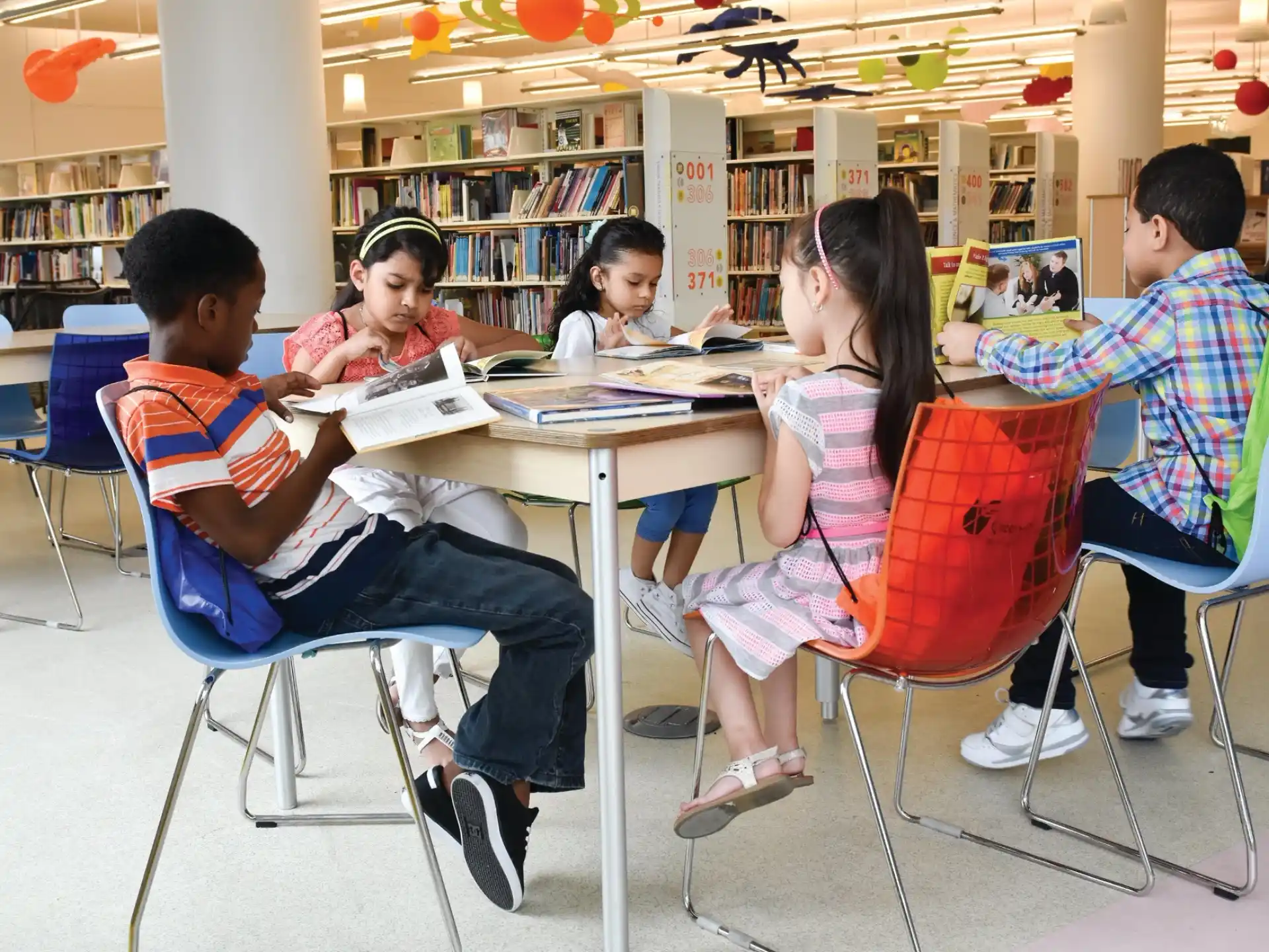 a group of people sitting at a table in a library